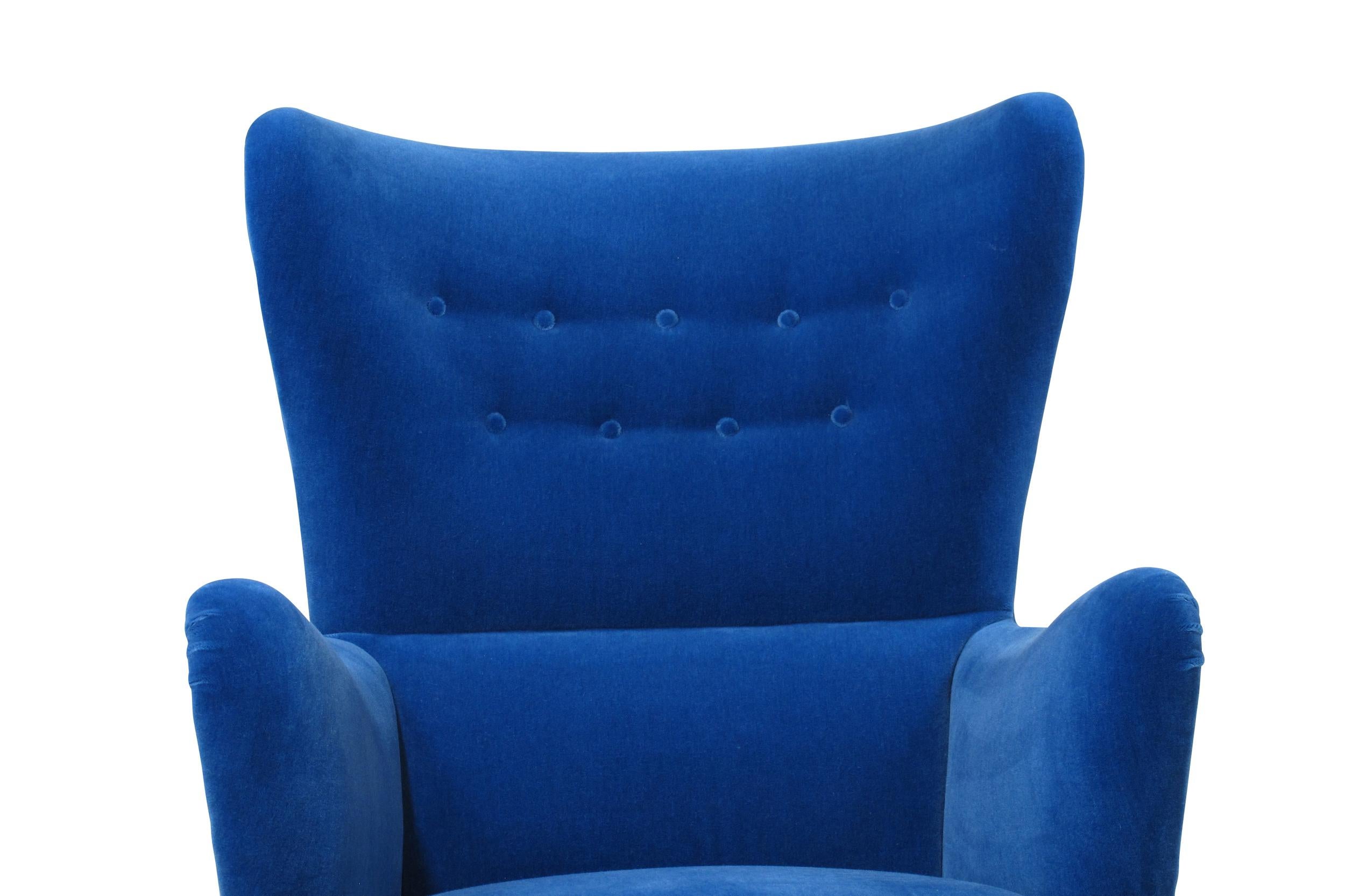 Midcentury Danish high back lounge chair crafted of a solid wood frame, with eight-way hand-tied springs in the seat, and horsehair padding. The curved button tufted backrest offers excellent back support. Newly upholstered in a blue mohair textile.