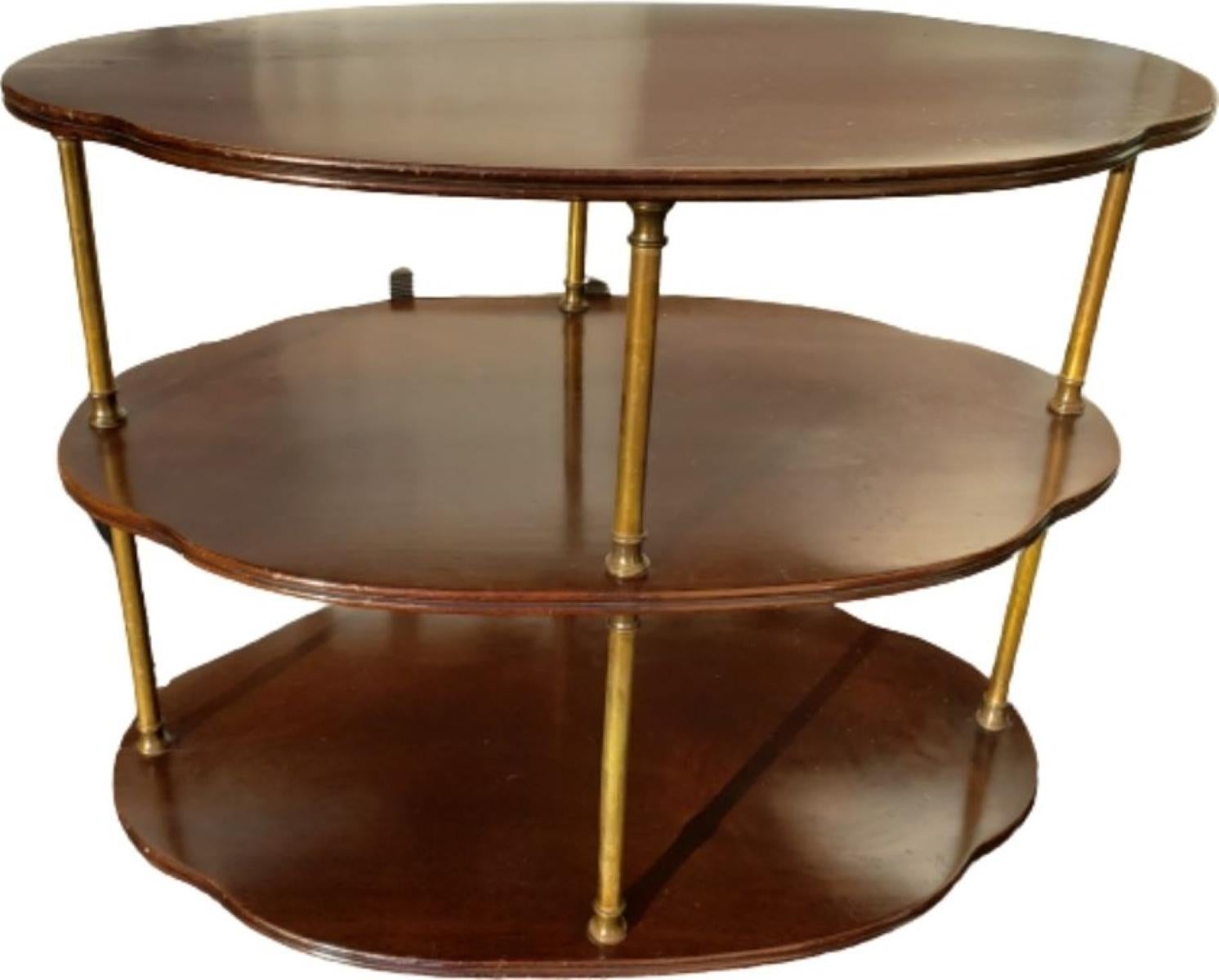 Hollywood Regency three tier Mahogany server with brass details and casters. This oval server on brass wheels is simple in design, yet very elegant. Brass columns and turnings on the sides. In great vintage condition with age-appropriate wear and
