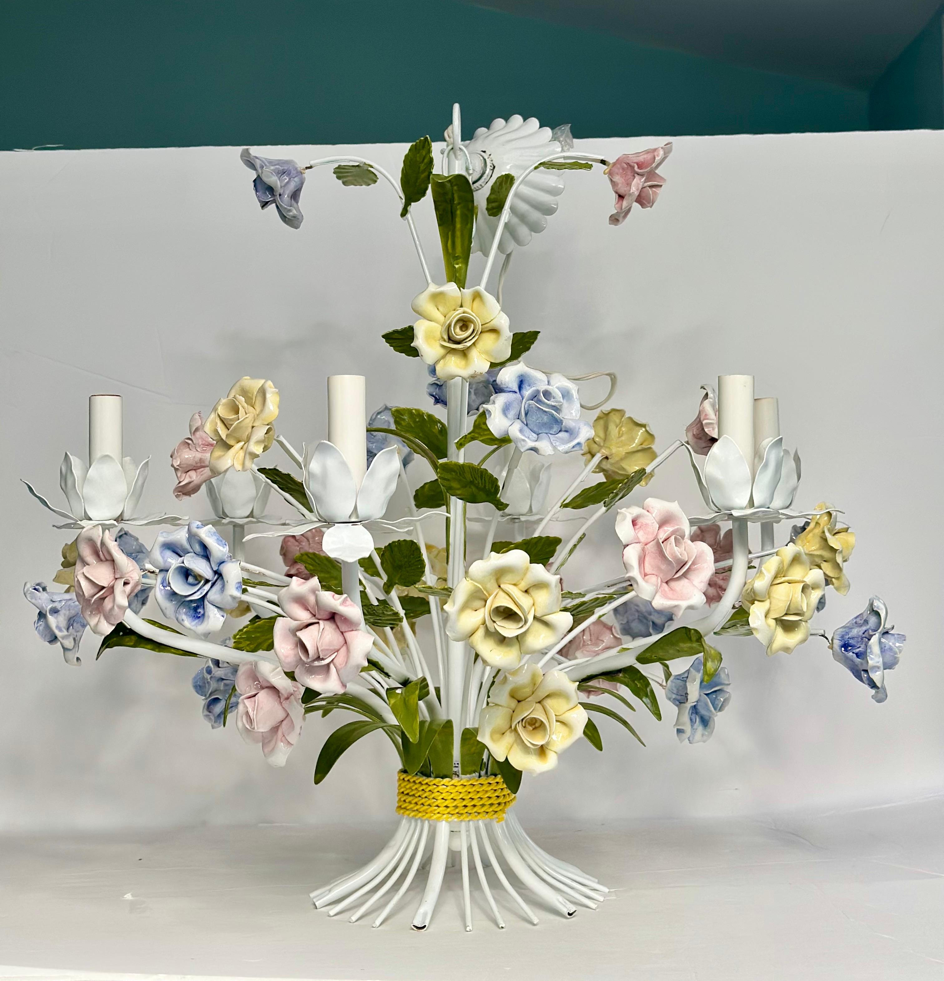 We are very pleased to offer an exquisite, vintage Tole chandelier showcasing the beauty and craftsmanship of Italian design, circa the 1950s.  The chandelier features intricate hand-painted porcelain flowers in soft pastel hues of blue, yellow and