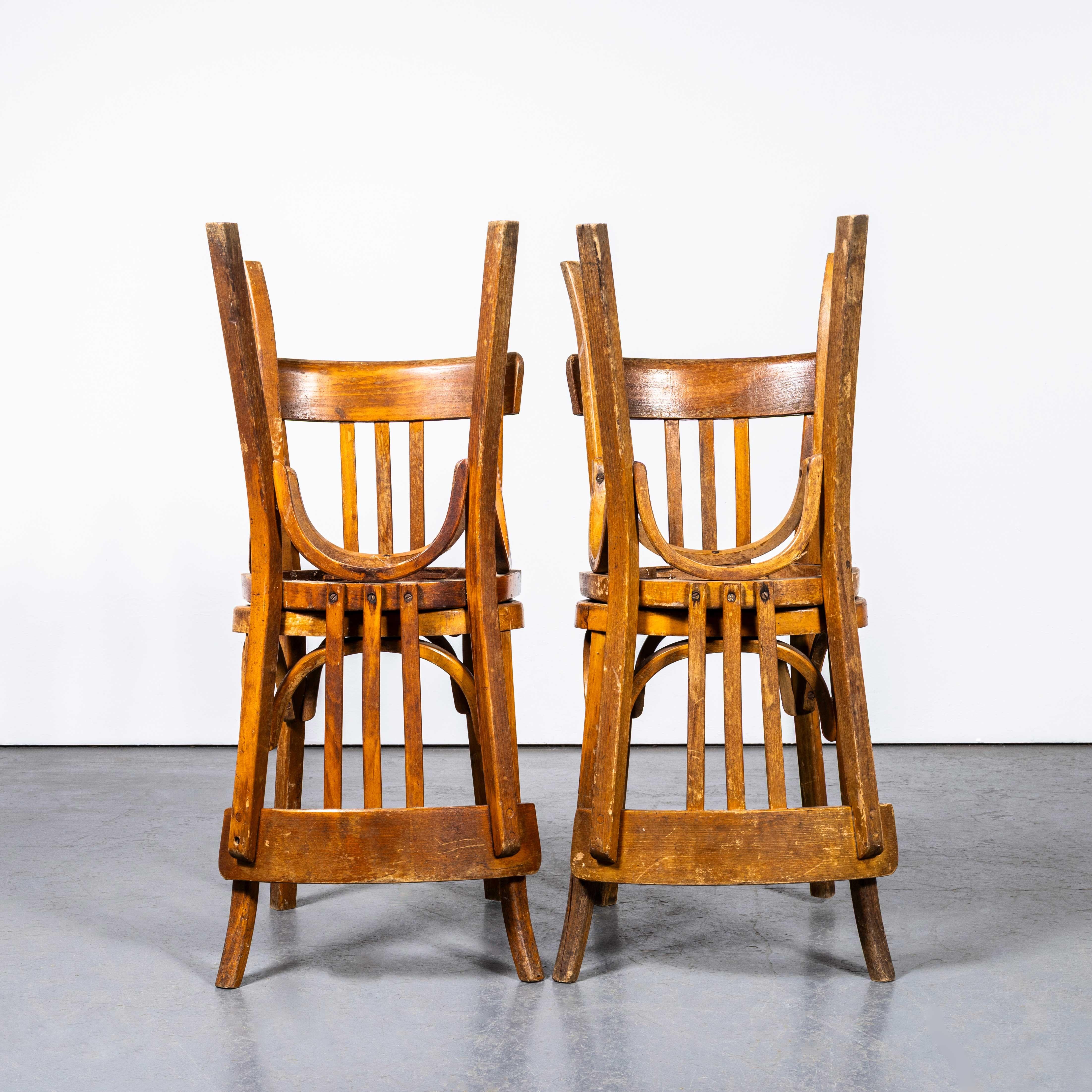 1950's Dark Oak Bentwood Baumann Dining Chairs - Set Of Four. 
Klassischer Bistrostuhl aus Buche, hergestellt in Frankreich von der Firma Baumann. Baumann ist ein etwas unauffälliger französischer Hersteller, der gerade beginnt, sich auf dem Markt