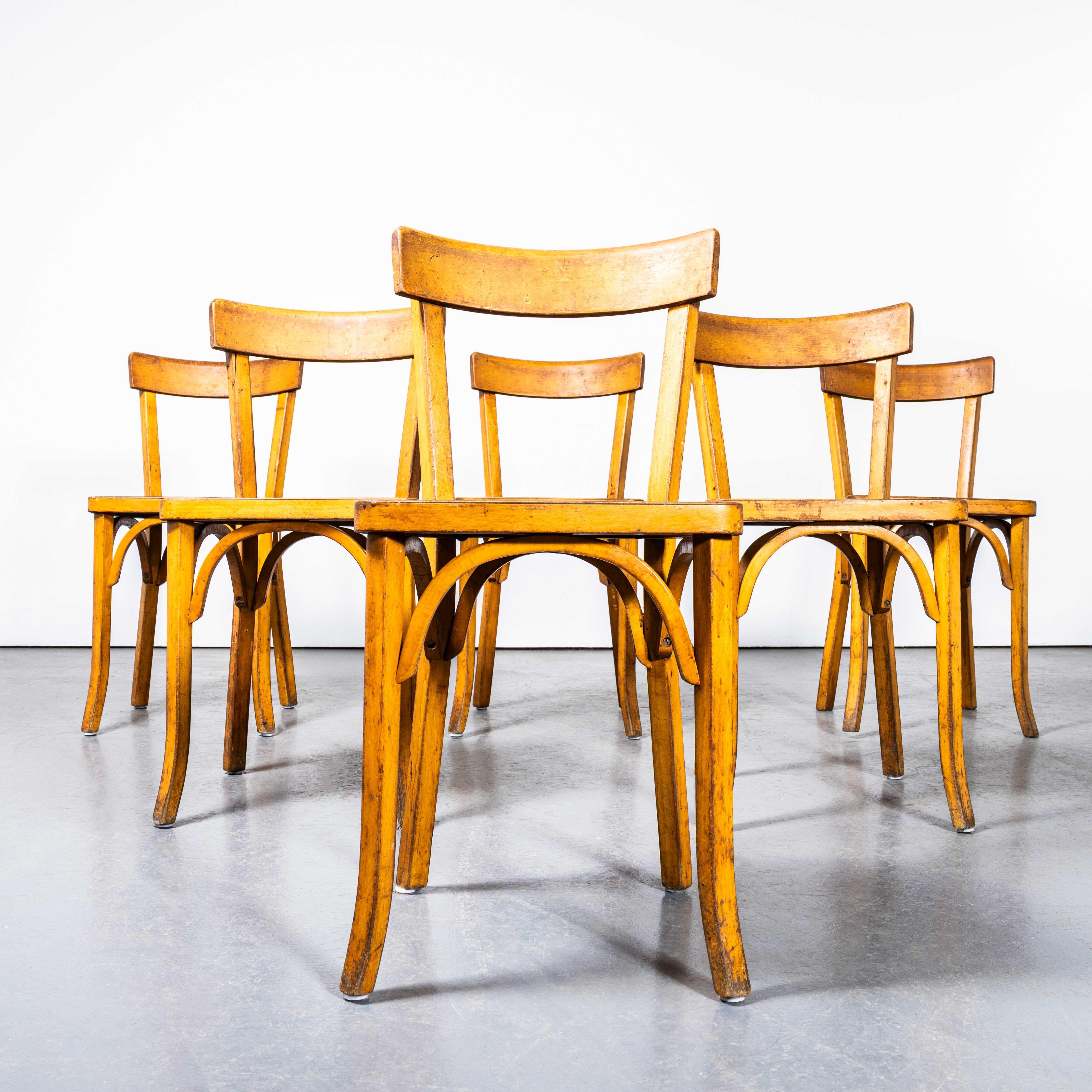 1950’s Honey Thin Slim Back Baumann Dining Chairs – Set Of Six. 
Classic beech bistro chair made in France by the maker Baumann. Baumann is a slightly off the radar French producer just starting to gain traction in the market. Baumann was founded in