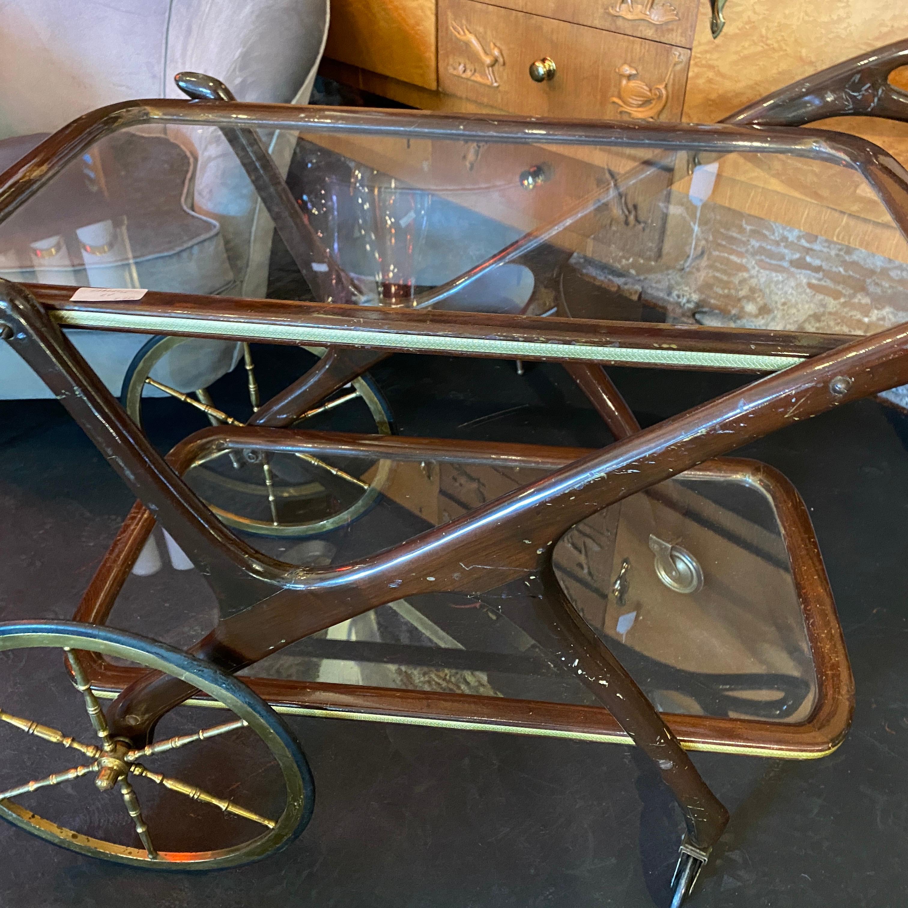 A mahogany and brass bar cart in original conditions. Brass it's in original patina, glasses are original.