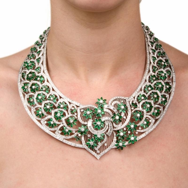 This captivating estate necklace is masterfully handcrafted in solid 18K white gold, weighing approximately 304.0 grams. The entire openwork lace pattern surface is embellished with emerald flowers and diamond buds and stems to produce this