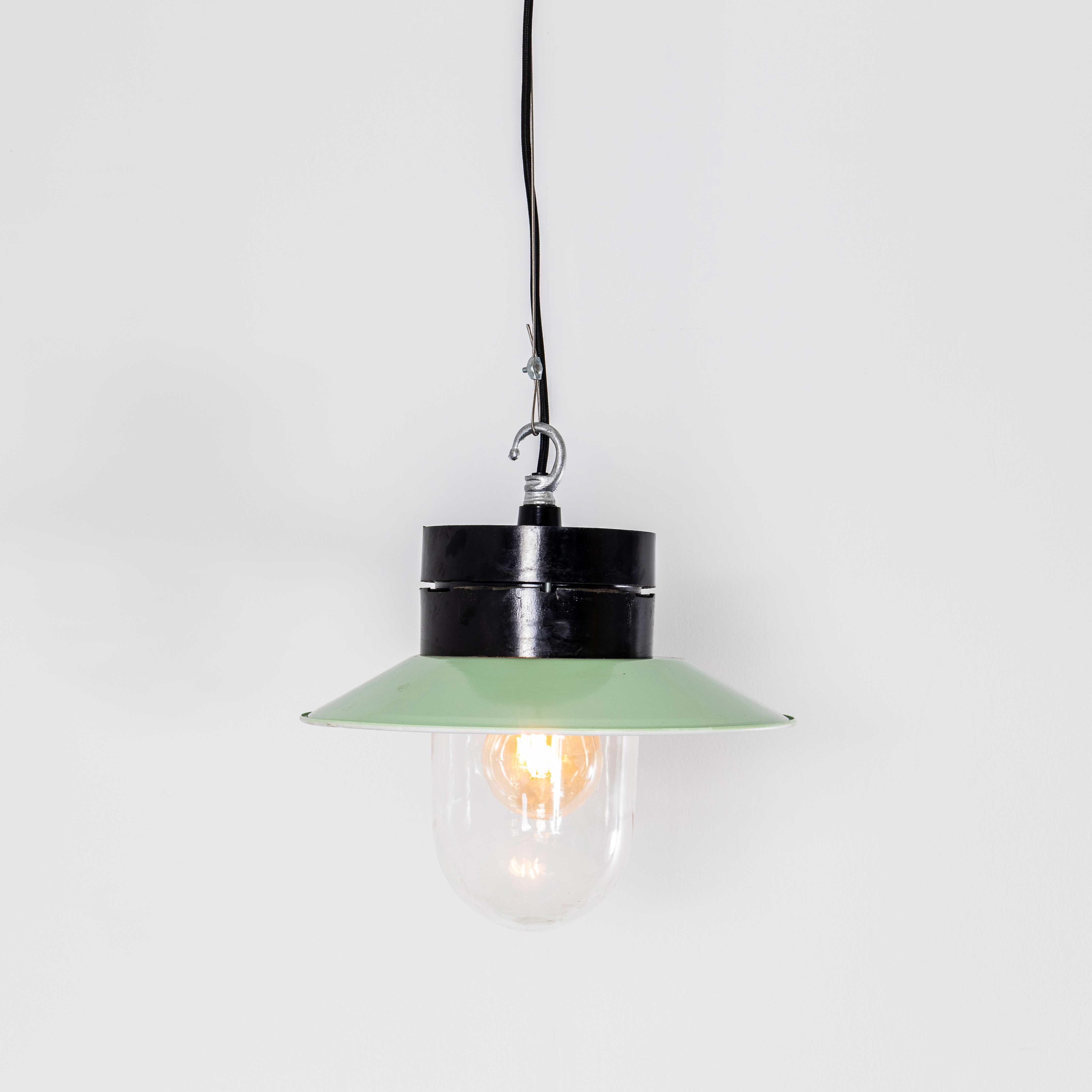 Lampade a sospensione industriali in bachelite degli anni '50. 
Nota bene: in questo design ci sono diverse cupole di vetro leggermente diverse tra loro; ogni design è elencato separatamente. Provenienti dall'Europa dell'Est, le lampade sono