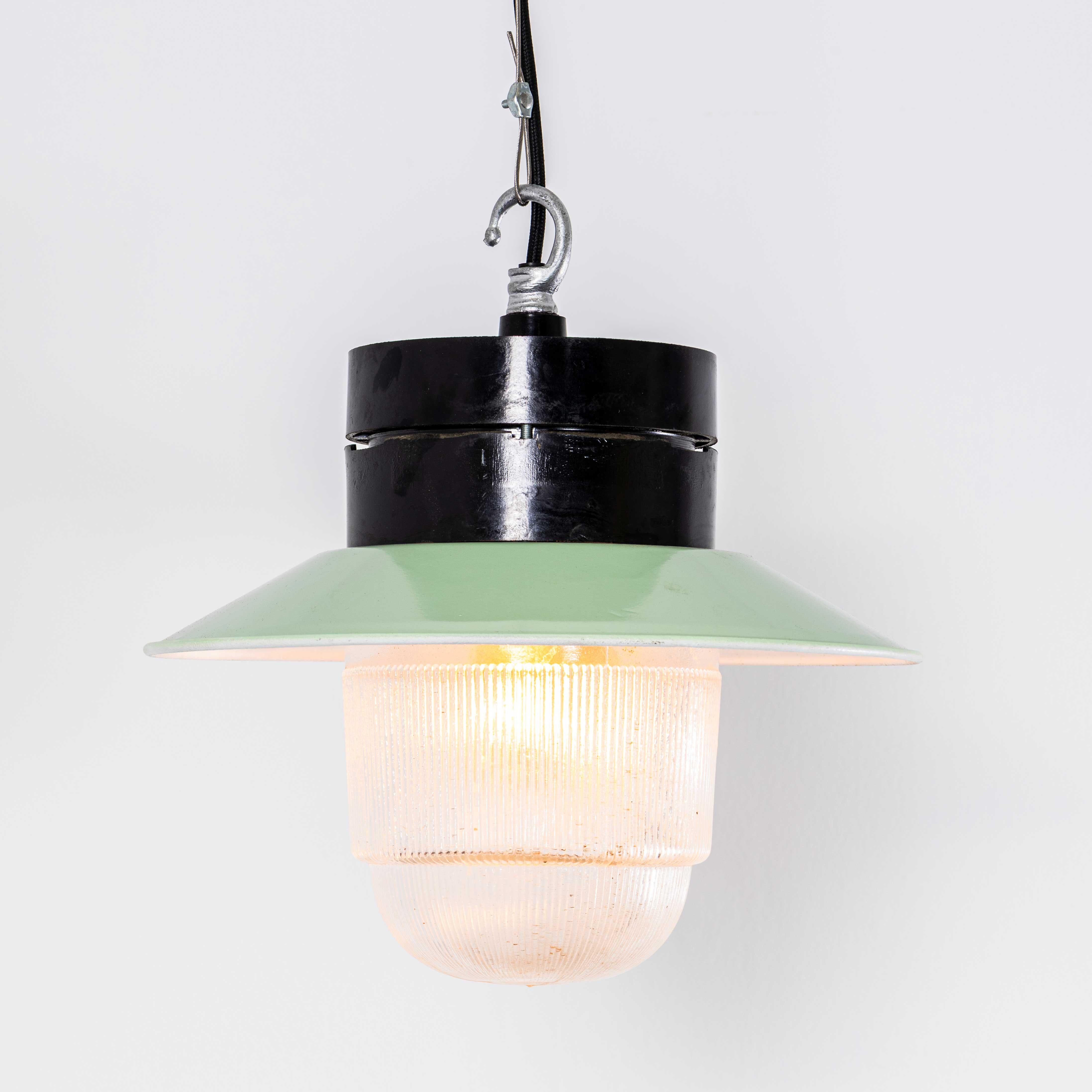 Lampade a sospensione industriali in bachelite degli anni '50. 
Nota bene: in questo design ci sono diverse cupole di vetro leggermente diverse tra loro; ogni design è elencato separatamente. Provenienti dall'Europa dell'Est, le lampade sono