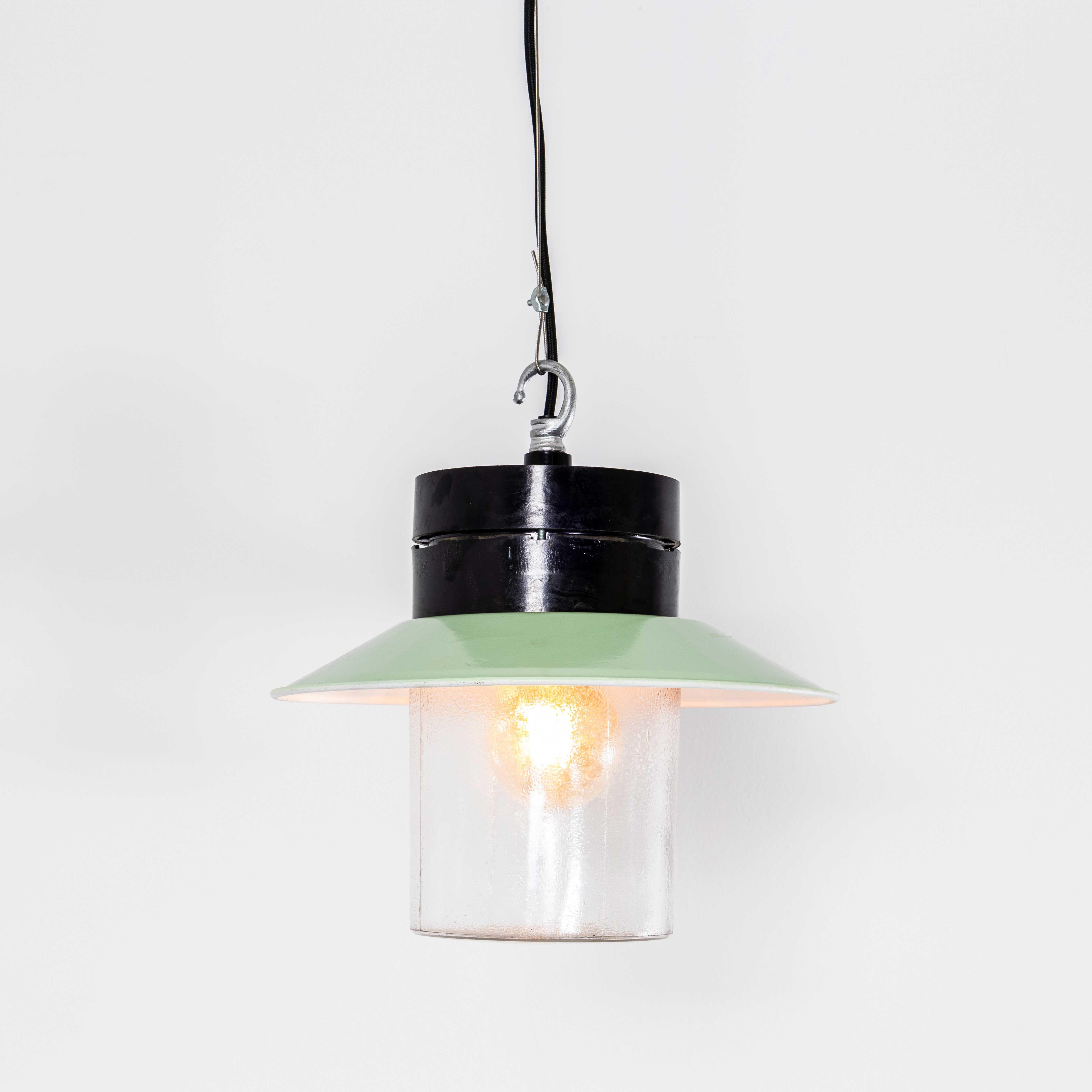 Lampade a sospensione industriali in bachelite degli anni '50. 
Nota bene: in questo design ci sono diverse cupole di vetro leggermente diverse tra loro; ogni design è elencato separatamente. Provenienti dall'Europa dell'Est, le lampade sono