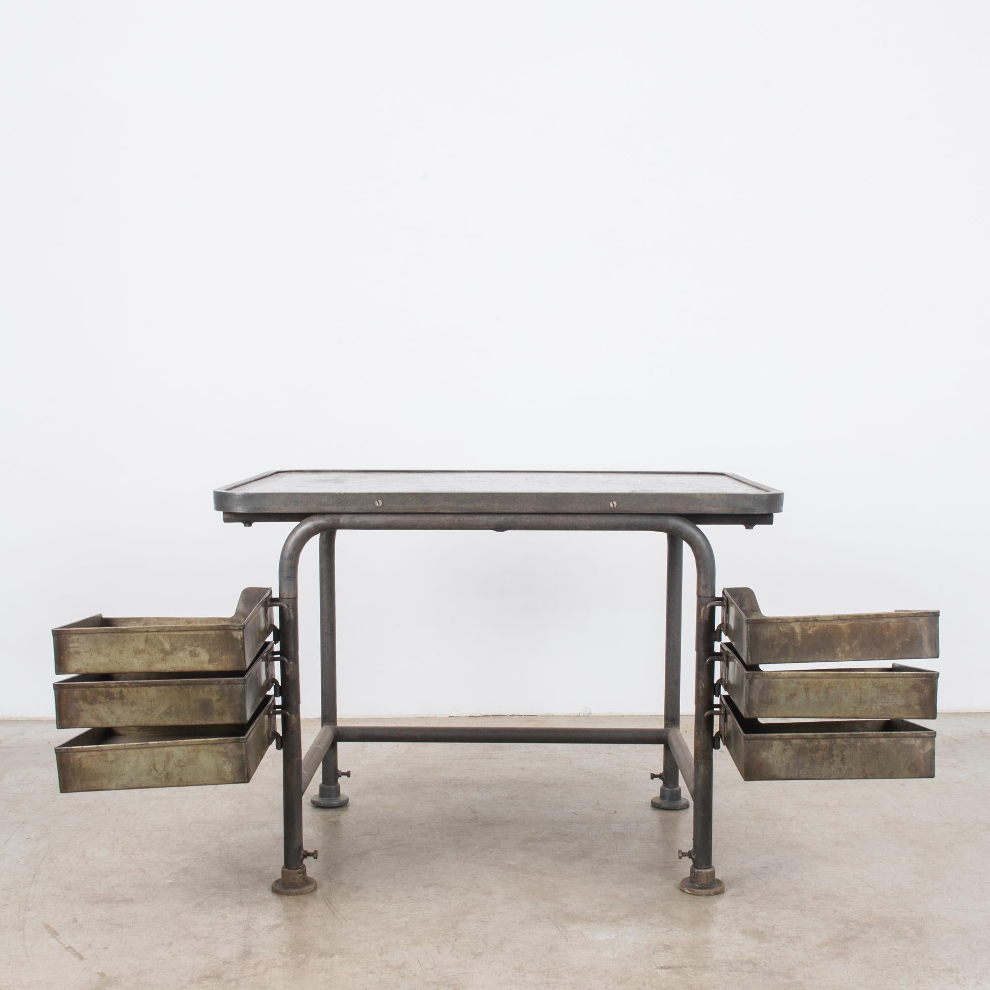 This metal work table was made in Belgium, circa 1950. Tubular steel construction is sturdy while refined, a practical and sleek construction designed for efficient work-- six drawer trays swilled out for easy access. Belgium is known for