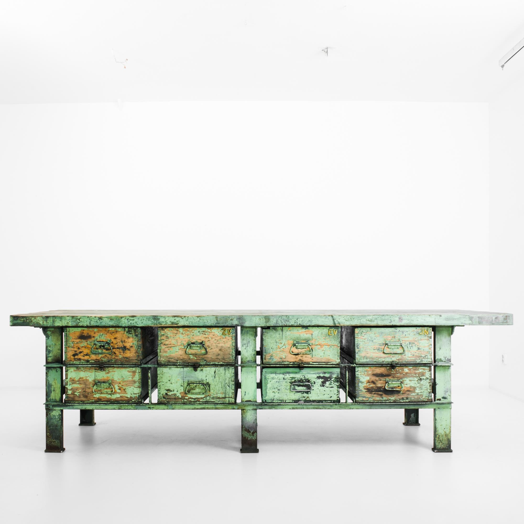 This worktable with a metal frame was made in the former Czechoslovakia, circa 1950. It displays a convivial spring green patina, seasoned to reveal the golden hues of the wooden tabletop and drawers. The table is sturdily constructed with six