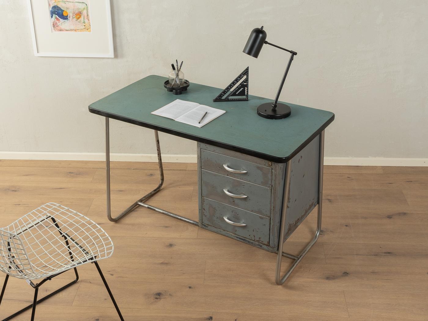 Unica scrivania industriale in design Bauhaus degli anni '50. Corpo in acciaio inossidabile e contenitore laccato con tre cassetti in metallo. Il piano è rivestito di Formica verde. 

Caratteristiche di qualità:
ottima lavorazione
materiali di alta