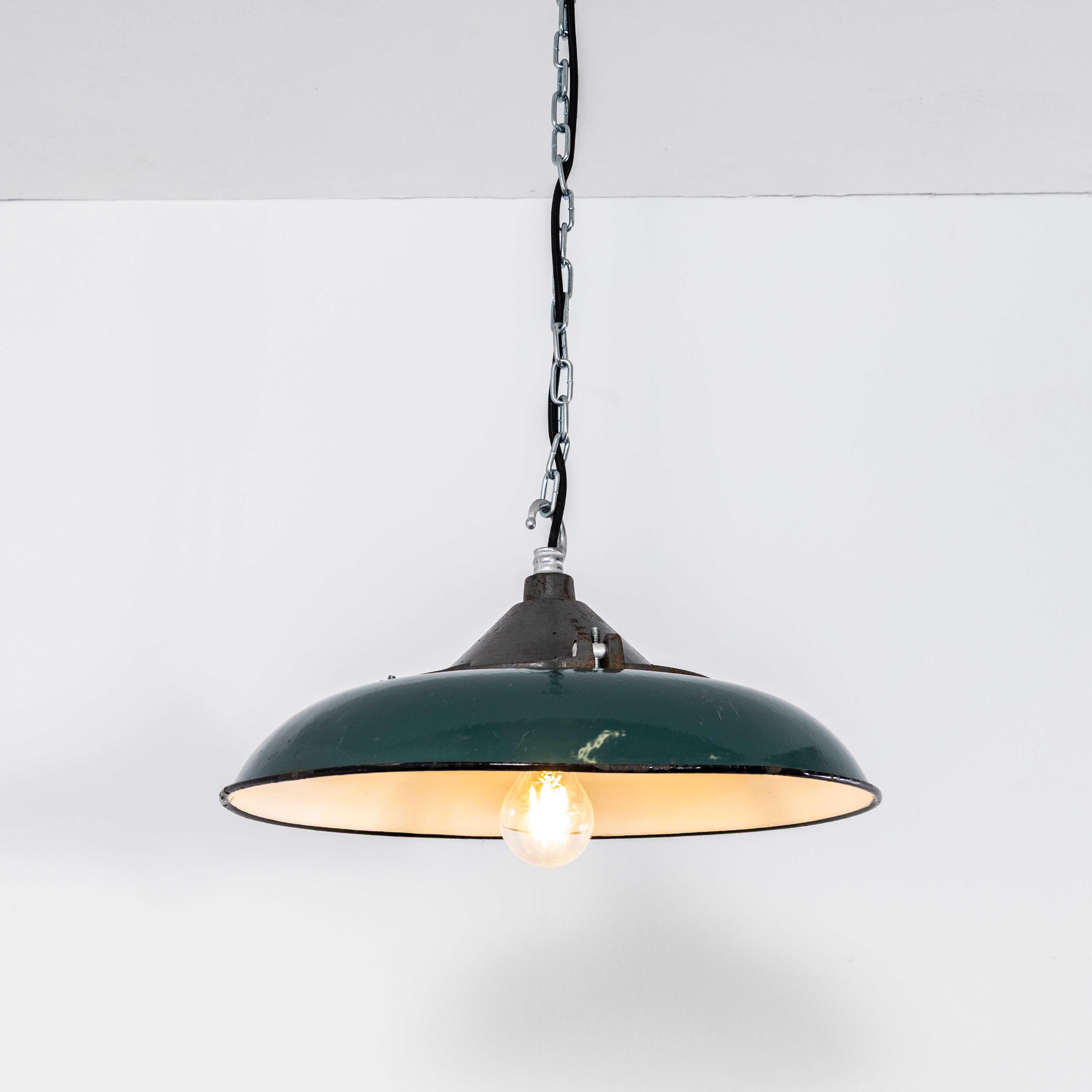 1950’s Industrial Green Disc Pendant Lamps. 

Listing is for one lamp. Made from spun and enamelled steel with cast heavy weight grey tops. The lamps were covered in paint, grease and dirt which was removed to reveal lamps in exceptional original