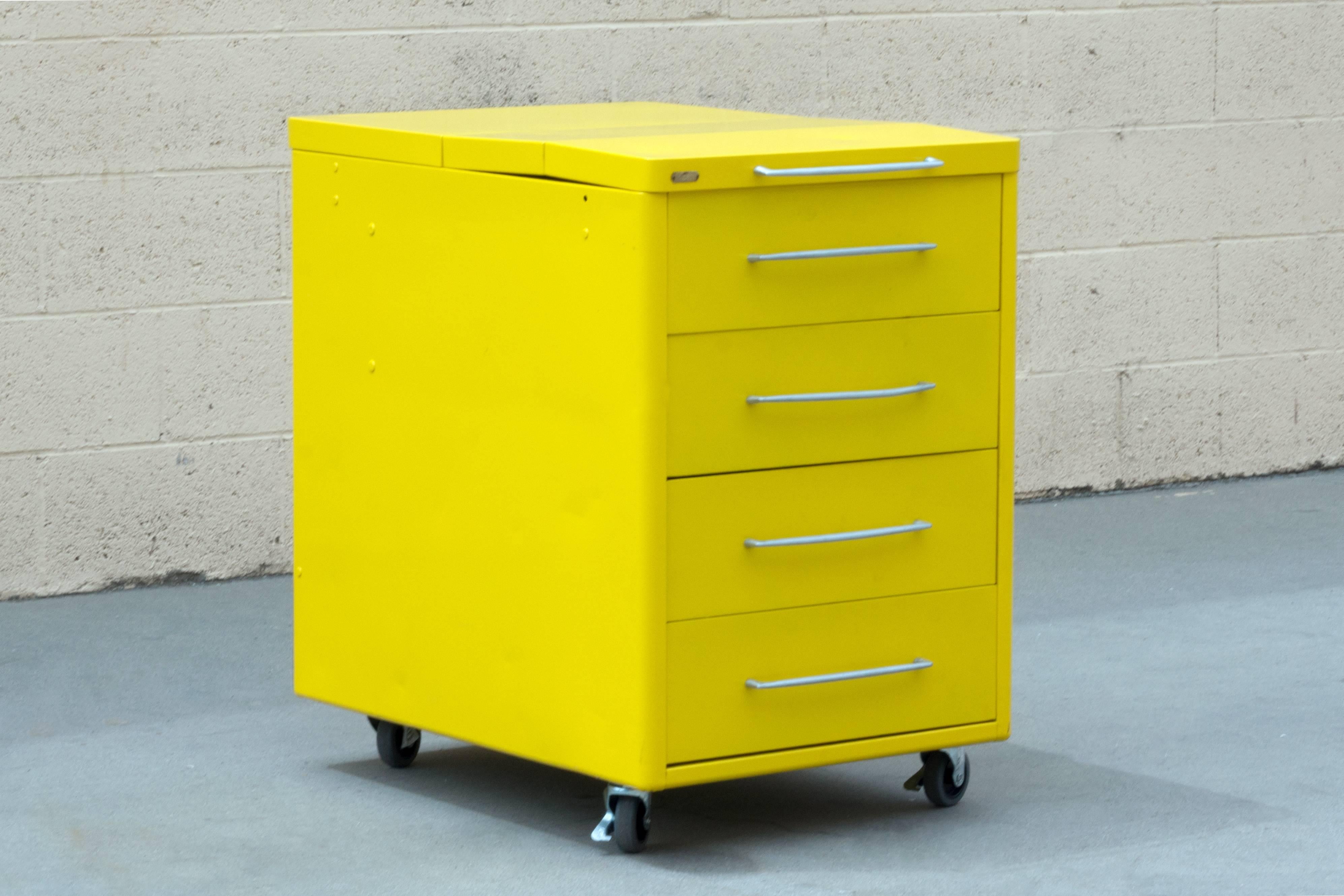 1950s industrial workshop cabinets refinished in gloss Sunshine Yellow. We have two cabinets that are almost identical. They are uniquely designed to function as a convertible flip-top tool box and storage unit in one. Featuring locking casters and