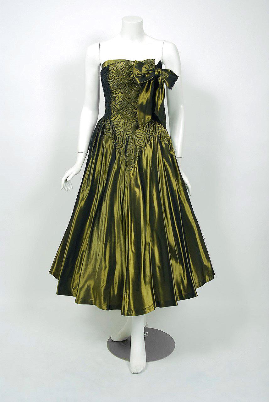 In this gorgeous 1950's olive-green party dress ensemble, the detailed construction and meticulous attention to detail are comparable to what you will find in modern couture. The garment is fashioned from light-weight soutache embroidered iridescent