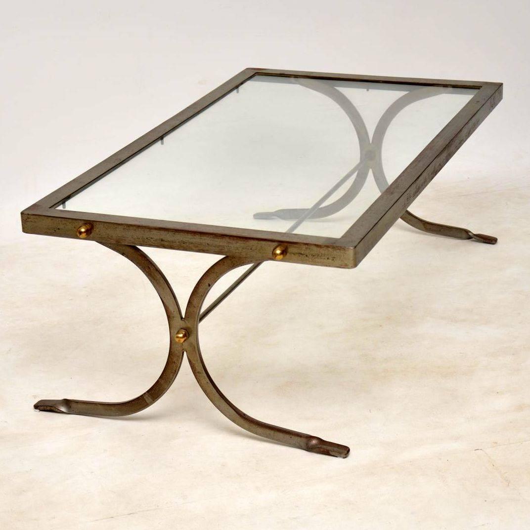 A beautiful and very well made vintage coffee table with an iron frame, brass fixtures and glass top. This dates from the 1950s-1960s, it’s in very good structural condition. The iron frame is beautifully distressed with heavy surface wear and