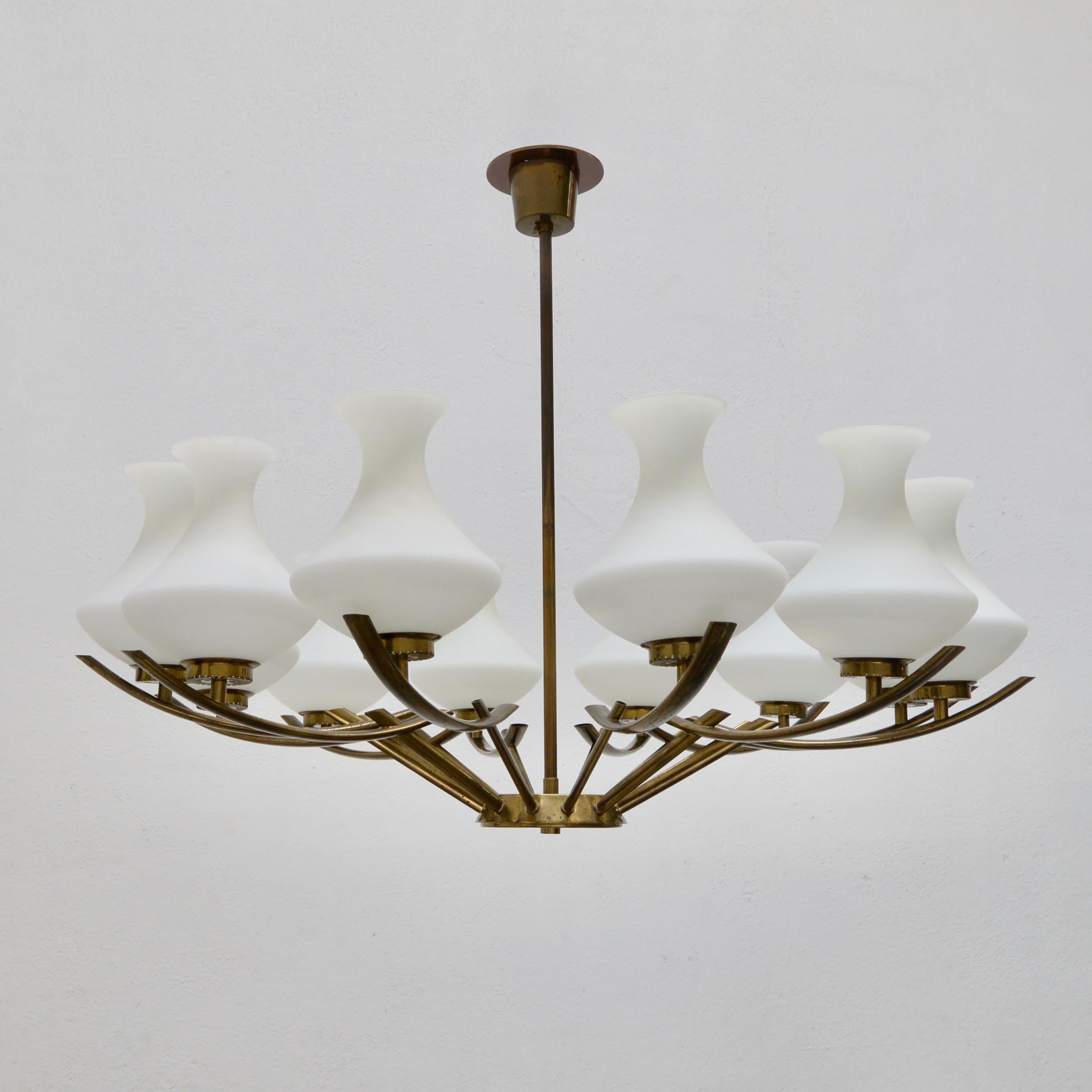 Of the period mid century Italian 12 shade 1950s naturally aged brass chandelier with hand blown glass shades. Wired with 12-E12 candelabra based sockets. Wired for use in the US. Light bulbs included with order.
Measurements:
OAD: 27” 
Diameter: