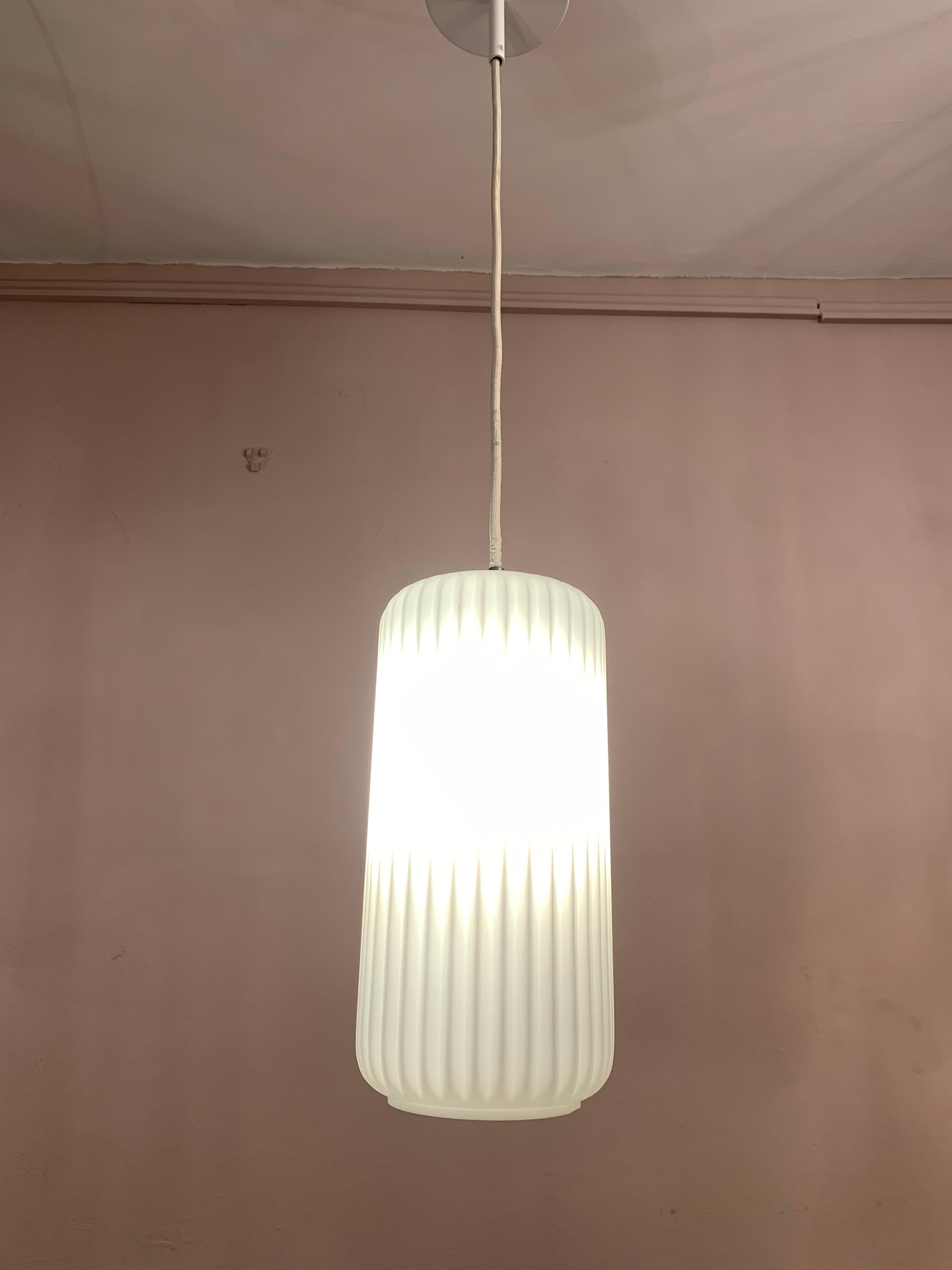 A 1950s Italian, modernist, opaline, glass pendant hanging light. The ribbed glass shades hang from a height adjustable white cord. A single E27 screw in bulb is required in each shade. The light is reminiscent of Stilnovo and Arredoluce lights of