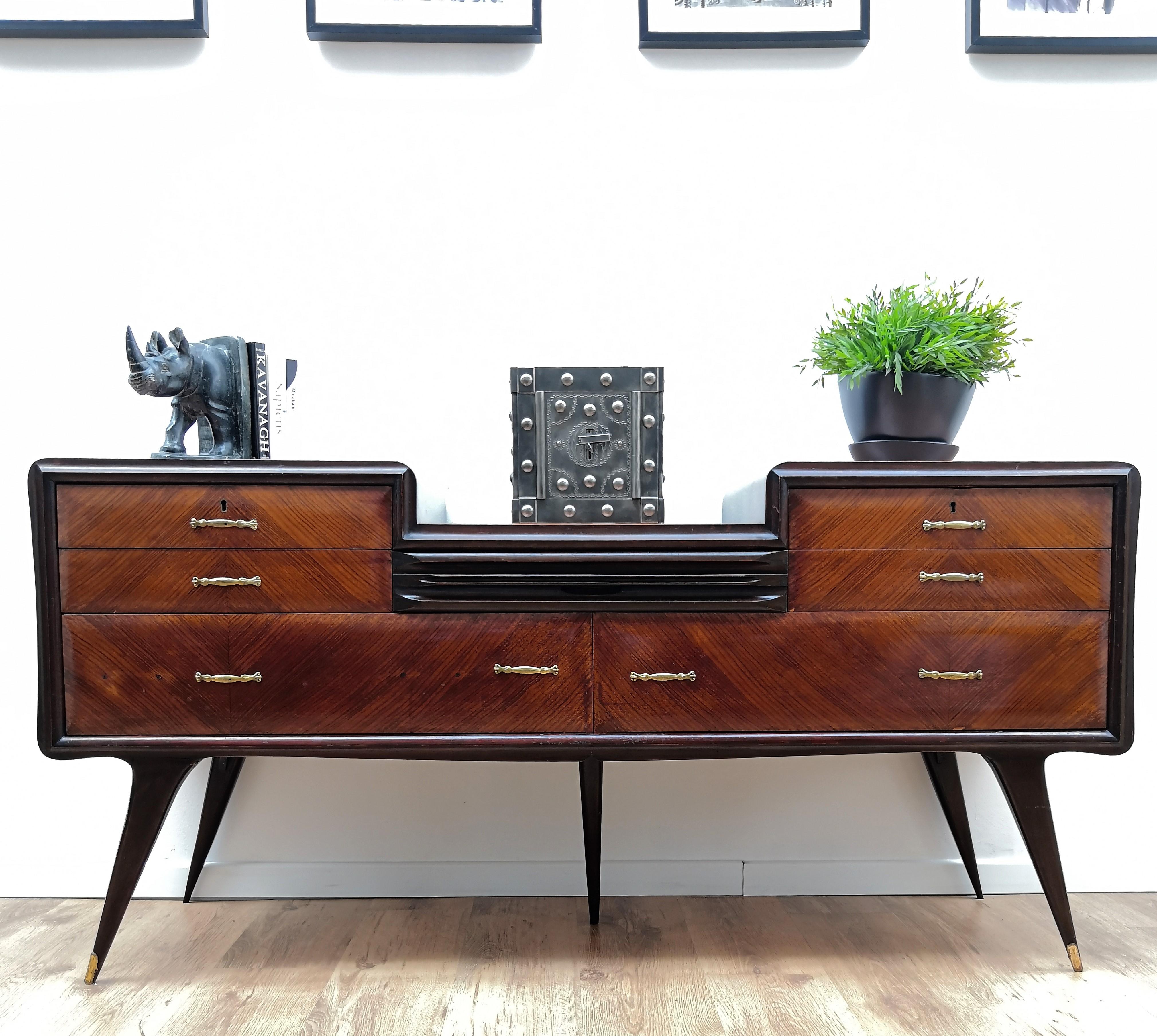 Beautiful Italian 1950s sideboard, credenza, buffet or chest of drawers with elegant and classic wood worked according its natural graining on the 6 drawers frontal drawers, with 3 levels copper-lacquered glass tops. A central hidden drawer follows