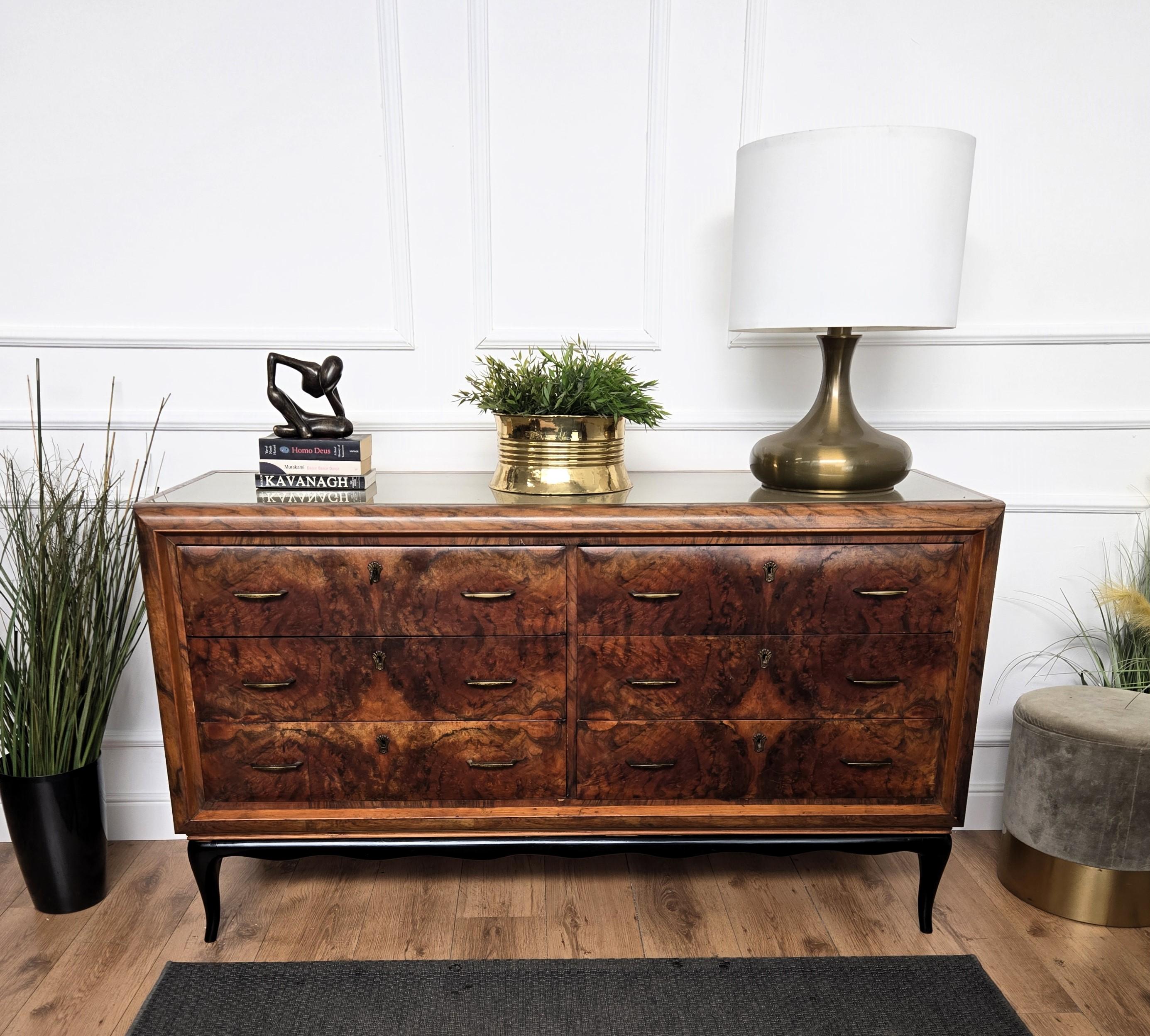 Beautiful Italian 1950s sideboard, credenza, buffet or chest of drawers with elegant and classic wood worked according its natural graining on the 6 frontal drawers with the brown-grey glass top and the final touch details of the original gilt brass