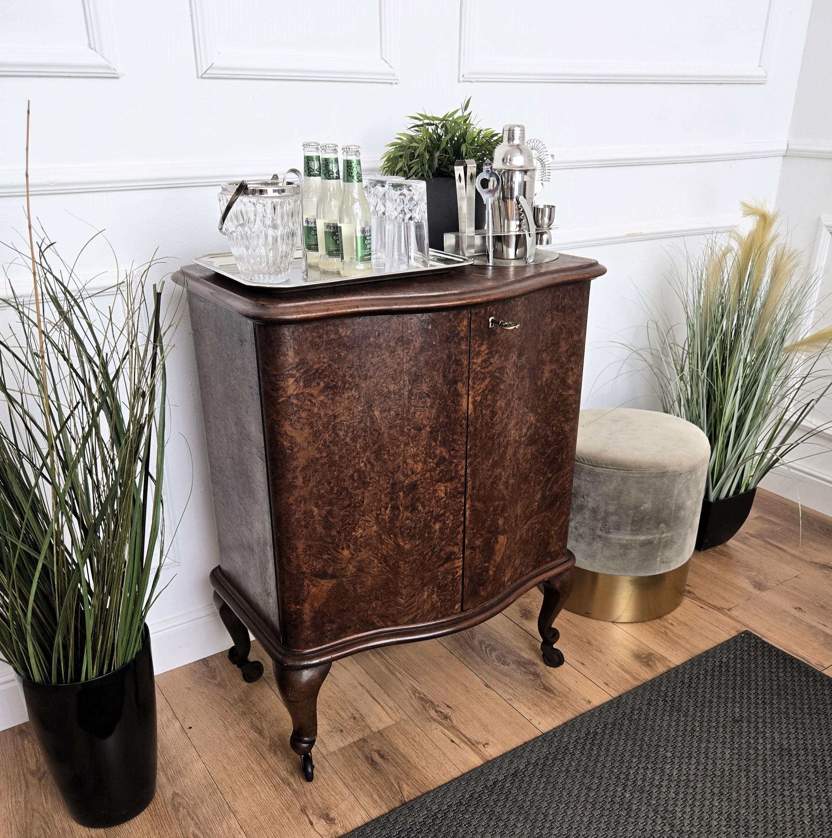 Unique et très élégant meuble de bar à sec italien Art déco du milieu du siècle, de forme ovale, en noyer, avec une double porte frontale présentant une partie intérieure étonnante avec des porte-bouteilles centraux qui coulissent vers l'avant. La