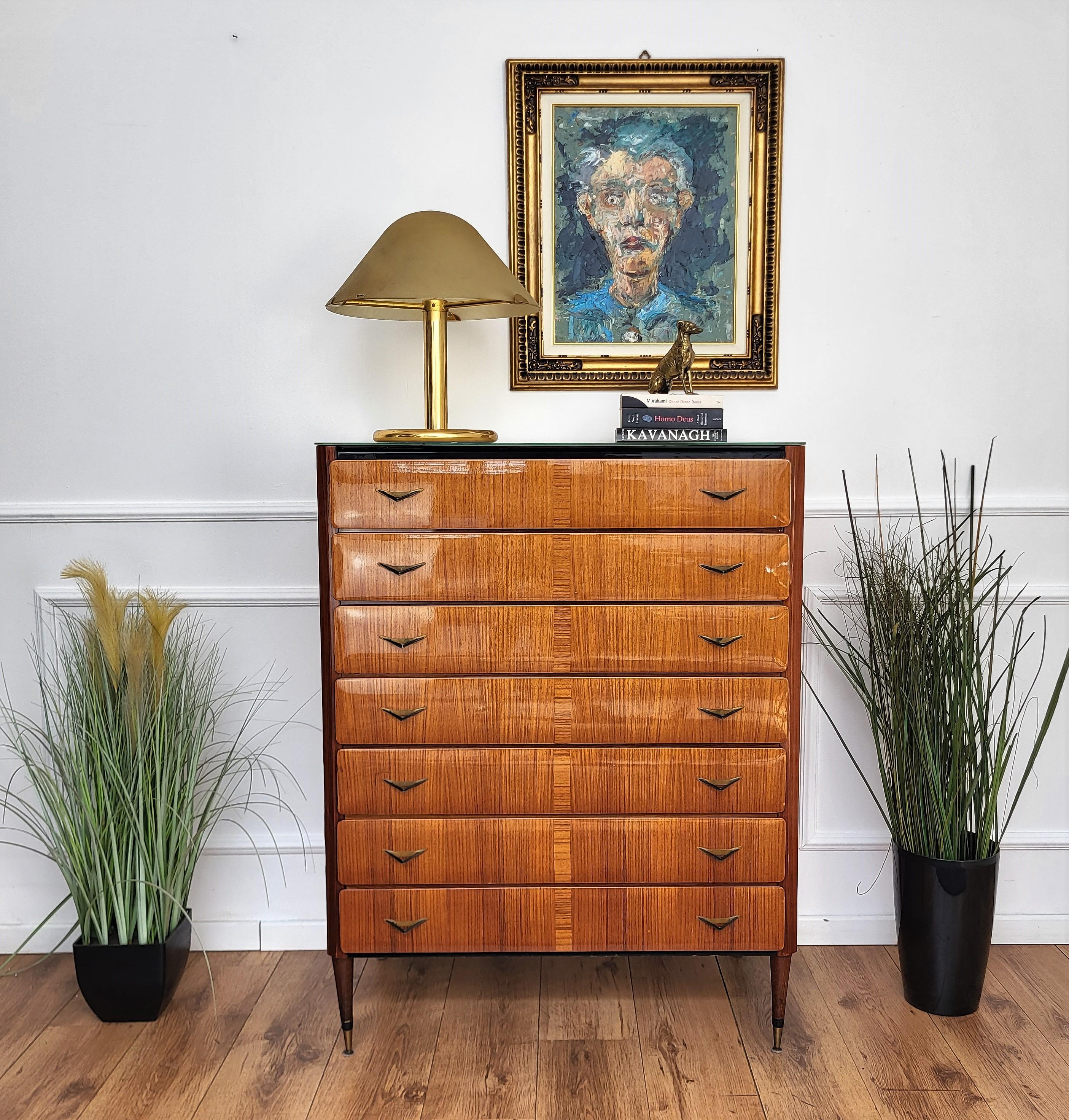 Important and elegantly shaped Italian Art Deco Mid-Century Modern dresser tallboy or chest of drawers, greatly designed front drawers, in beautiful veneer burl wood with shaped and beveled white glass top. This typical dresser has seven drawers,