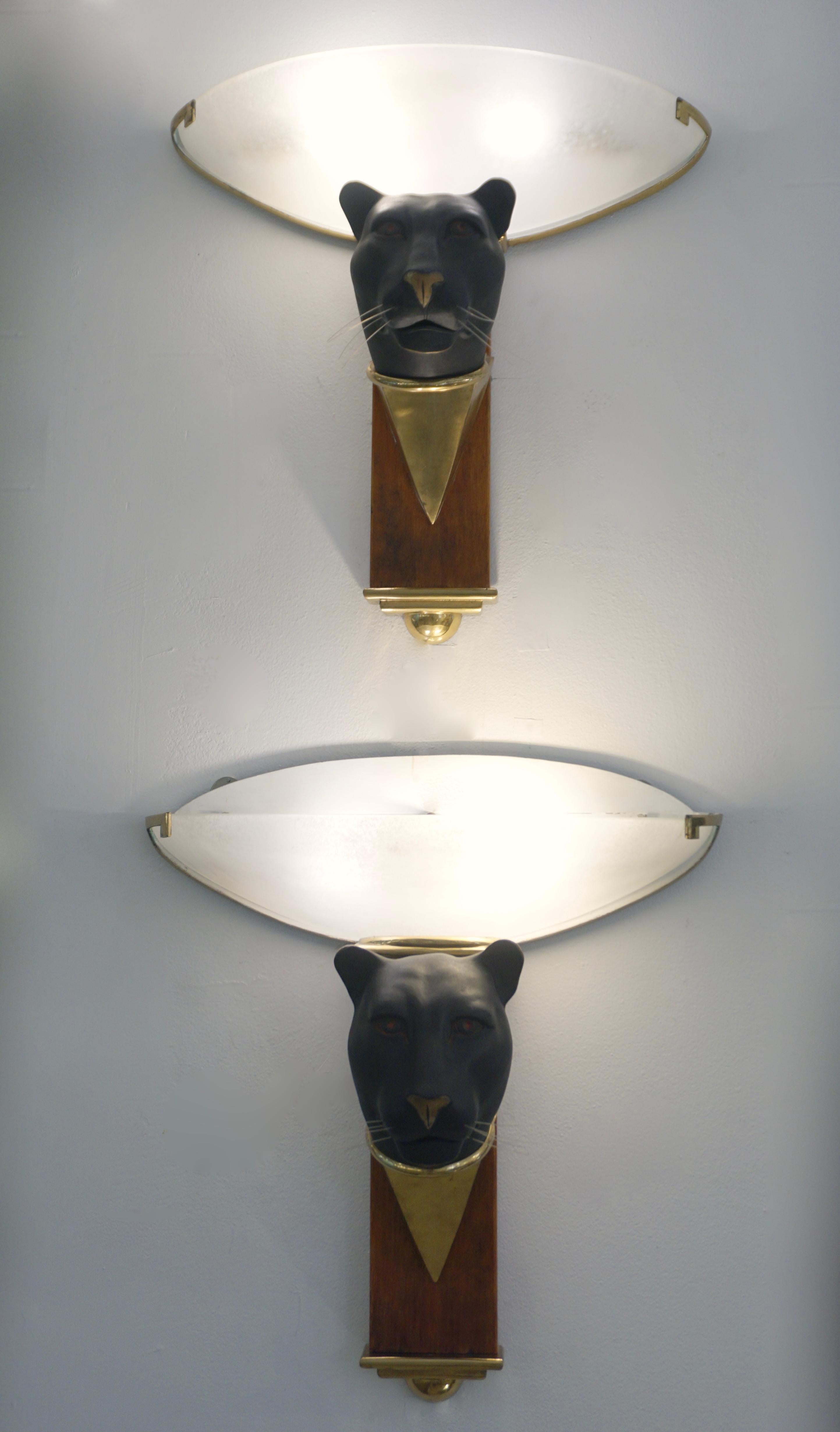 A very rare pair of Italian animals sculptural sconces of ethnic design, representing the head of black panthers with whiskers in black patinated bronze resting on conical brass support leaning on a wooden column, the bottom finished with an Art