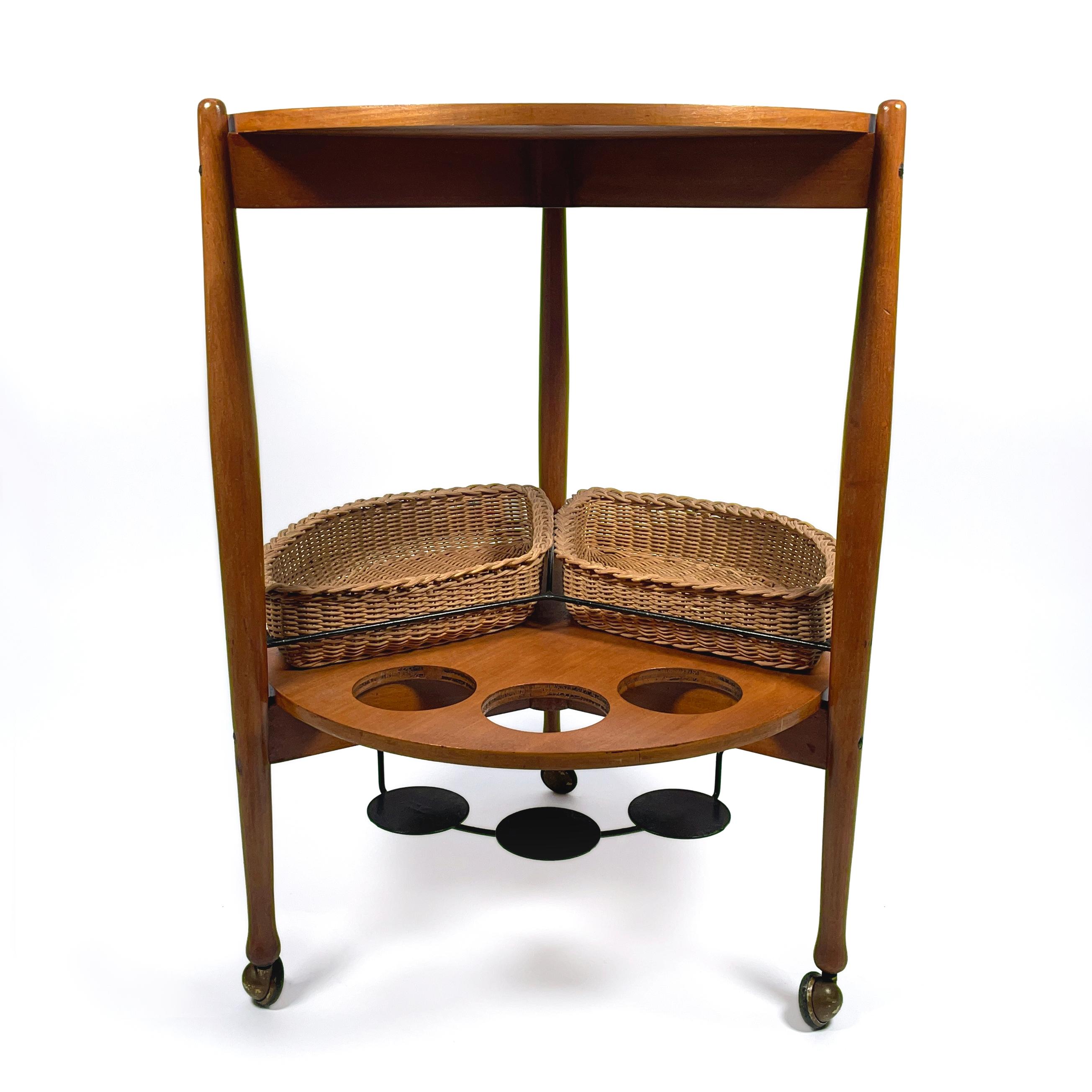 Very decorative and versatile vintage bar cart, serving trolley from the 1950s by Fratelli Reguitti.
The bar cart is made of solid wood (with iron and brass details), has 3 bottle holders and is fitted with two removable original wicker baskets.