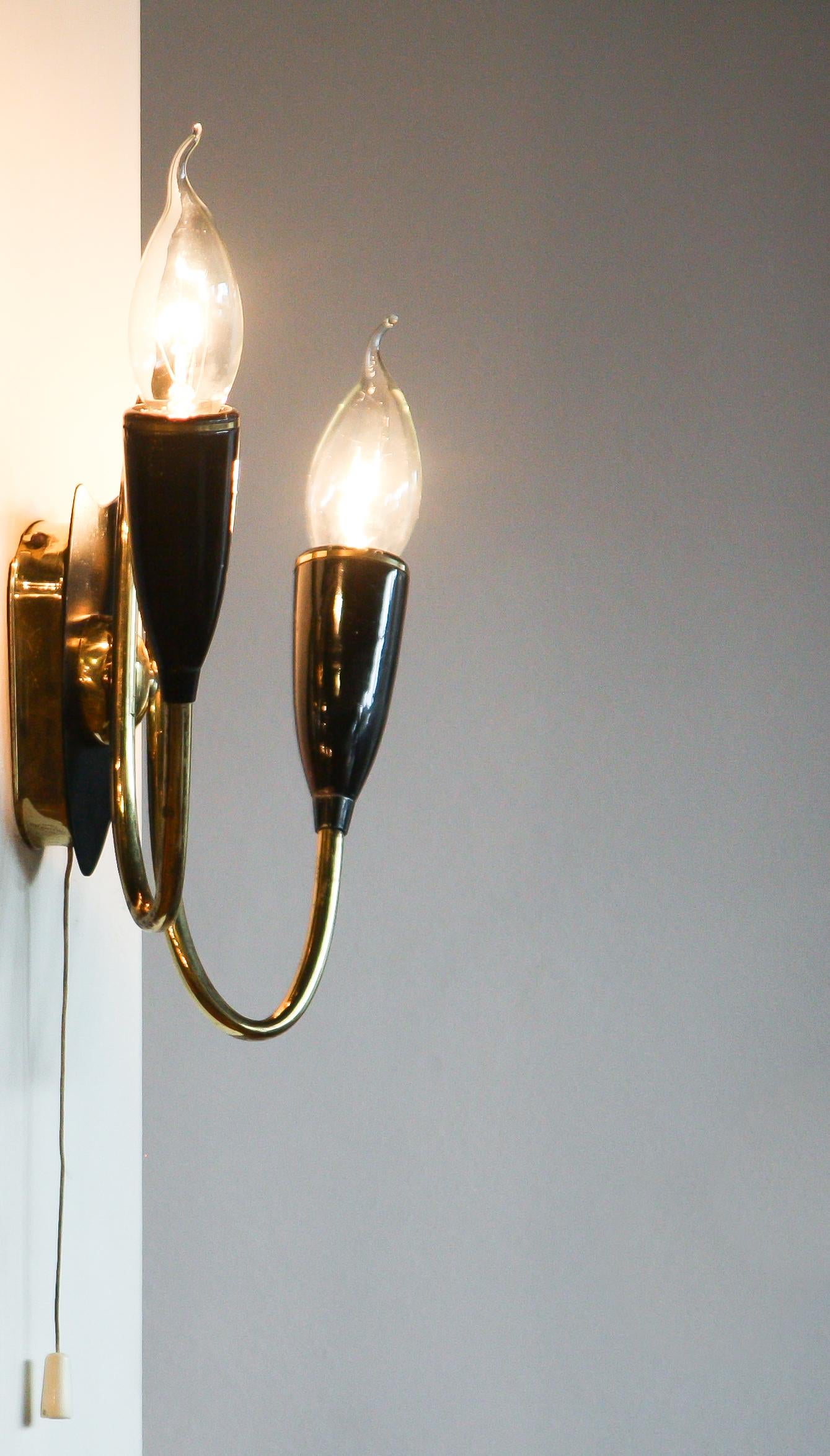 Schöne italienische Wandlampe aus Messing.
Die Lampe besteht aus zwei Messingarmen mit schwarzen Metallbefestigungen.
Es ist in einem guten und funktionierenden Zustand.
Zeitraum: 1950s.
Abmessungen: H 20 cm, B 18 cm, T 10 cm.
