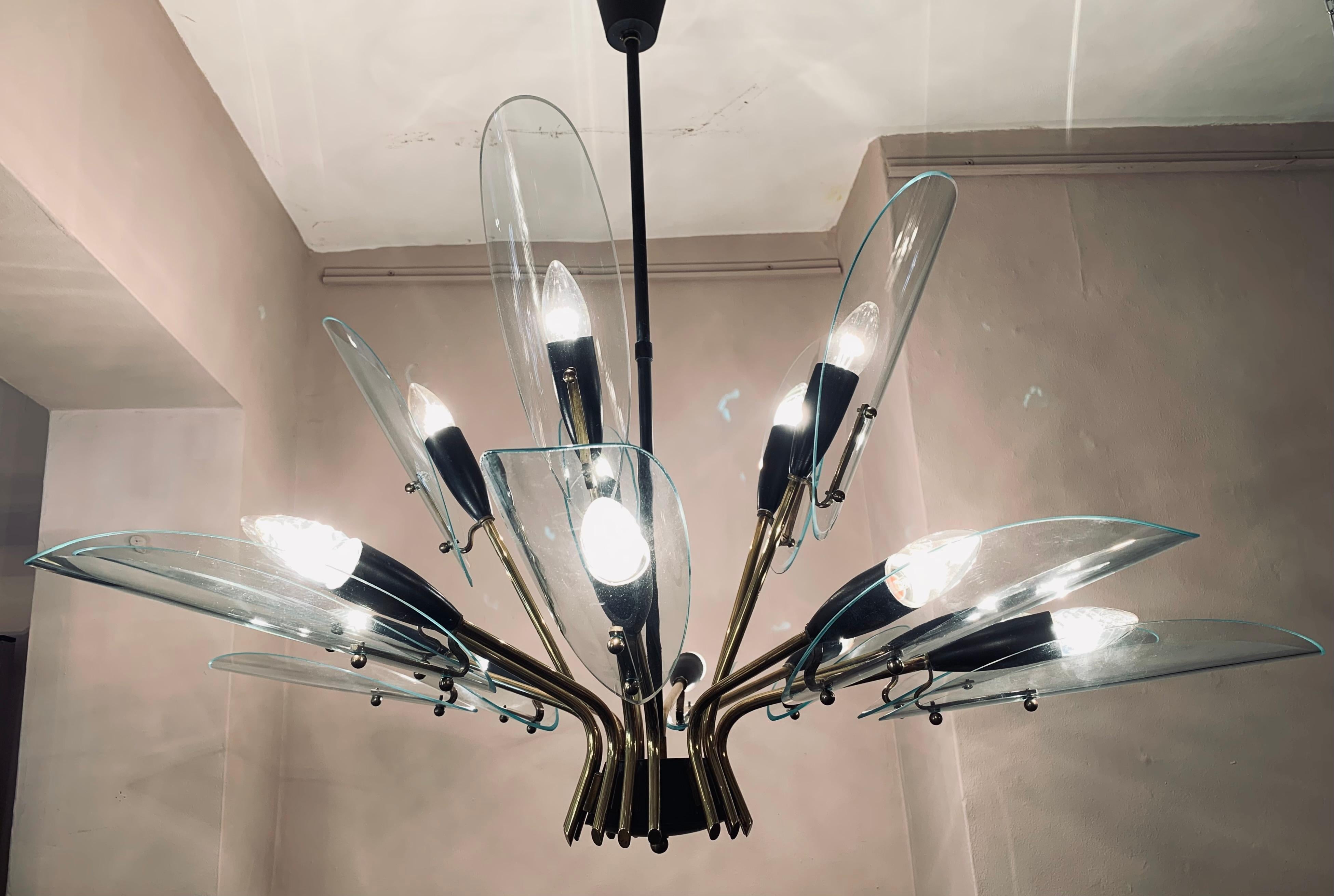 An absolutely stunning 1950s Italian brass and glass chandelier in the style of Max Ingrand for Fontana Arte. The chandelier is composed of 15 clear glass bevelled petals - 5 around the upper section and 10 around the lower which are all supported