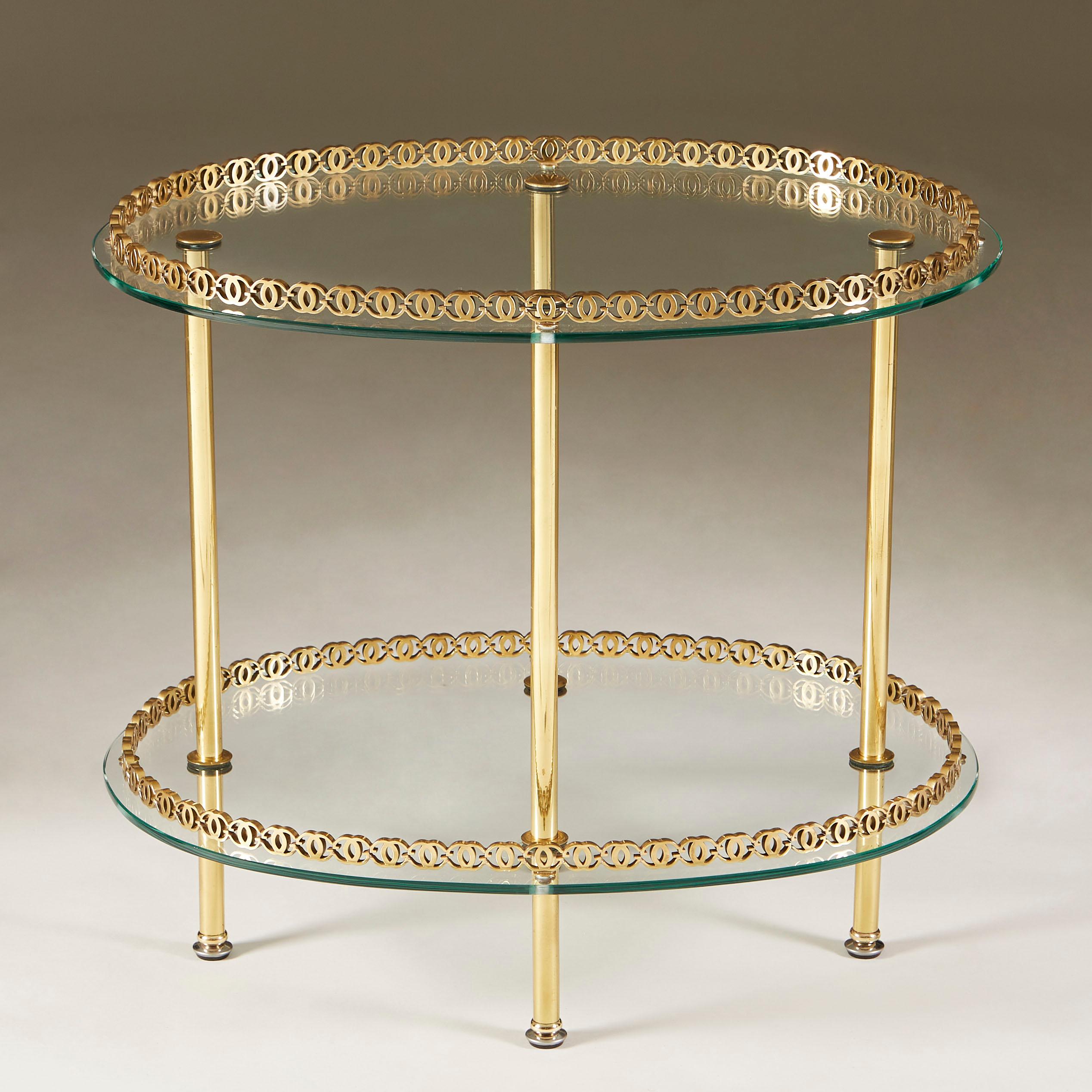 Elegant oval table with two highly decorative brass rods surrounding the glass shelves.