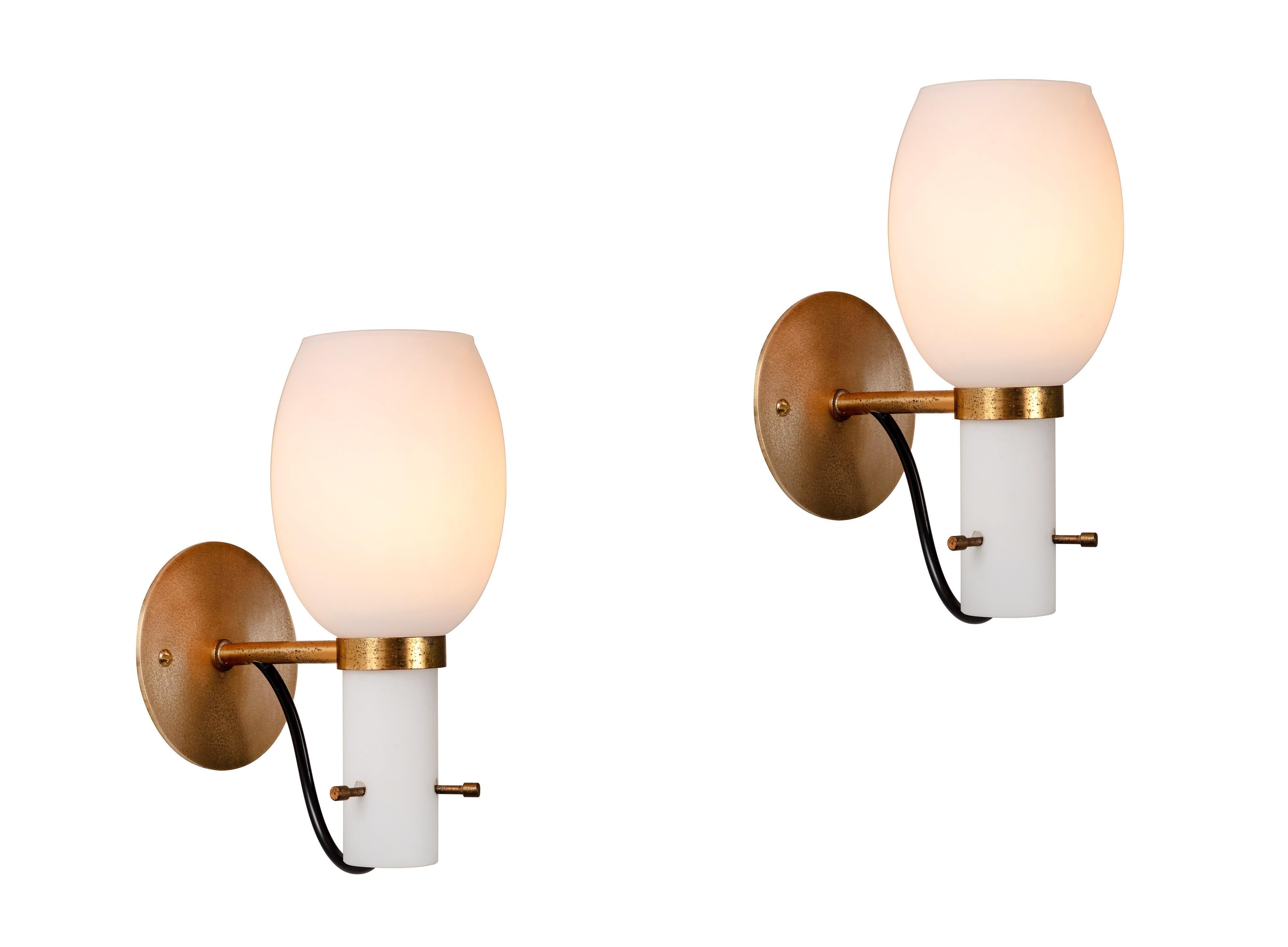1950s Italian brass and glass sconces attributed to Stilnovo. Executed in patinated brass and sculptural opaline glass. Ingeniously held in place with 3 decorative and richly patinated brass screws. An elegant and refined lighting design reflecting