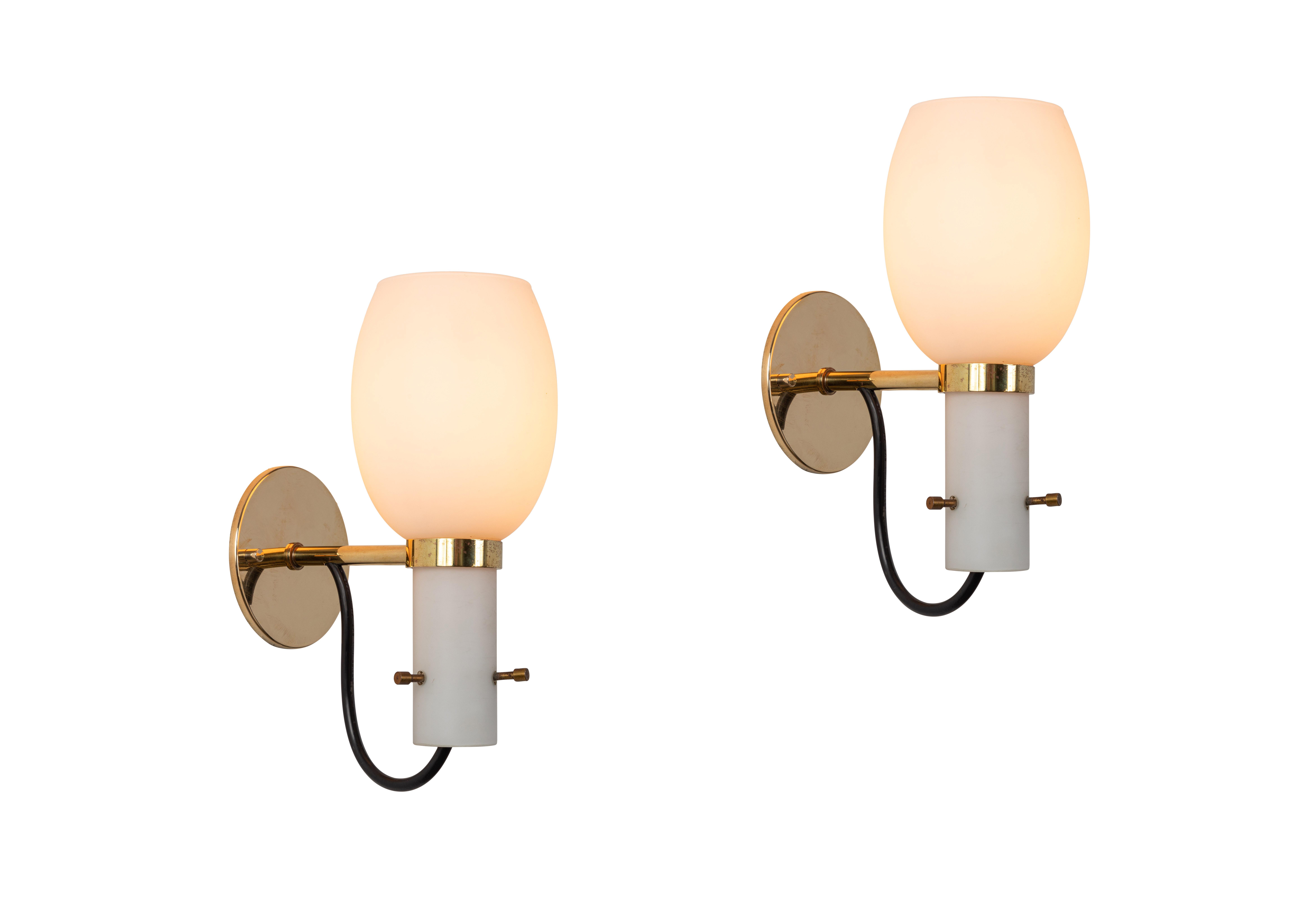 1950s Italian brass and glass sconces attributed to Stilnovo. Executed in polished brass and sculptural opaline glass, with custom brass backplate for mounting over a standard American J-box. Ingeniously held in place with 3 decorative and richly