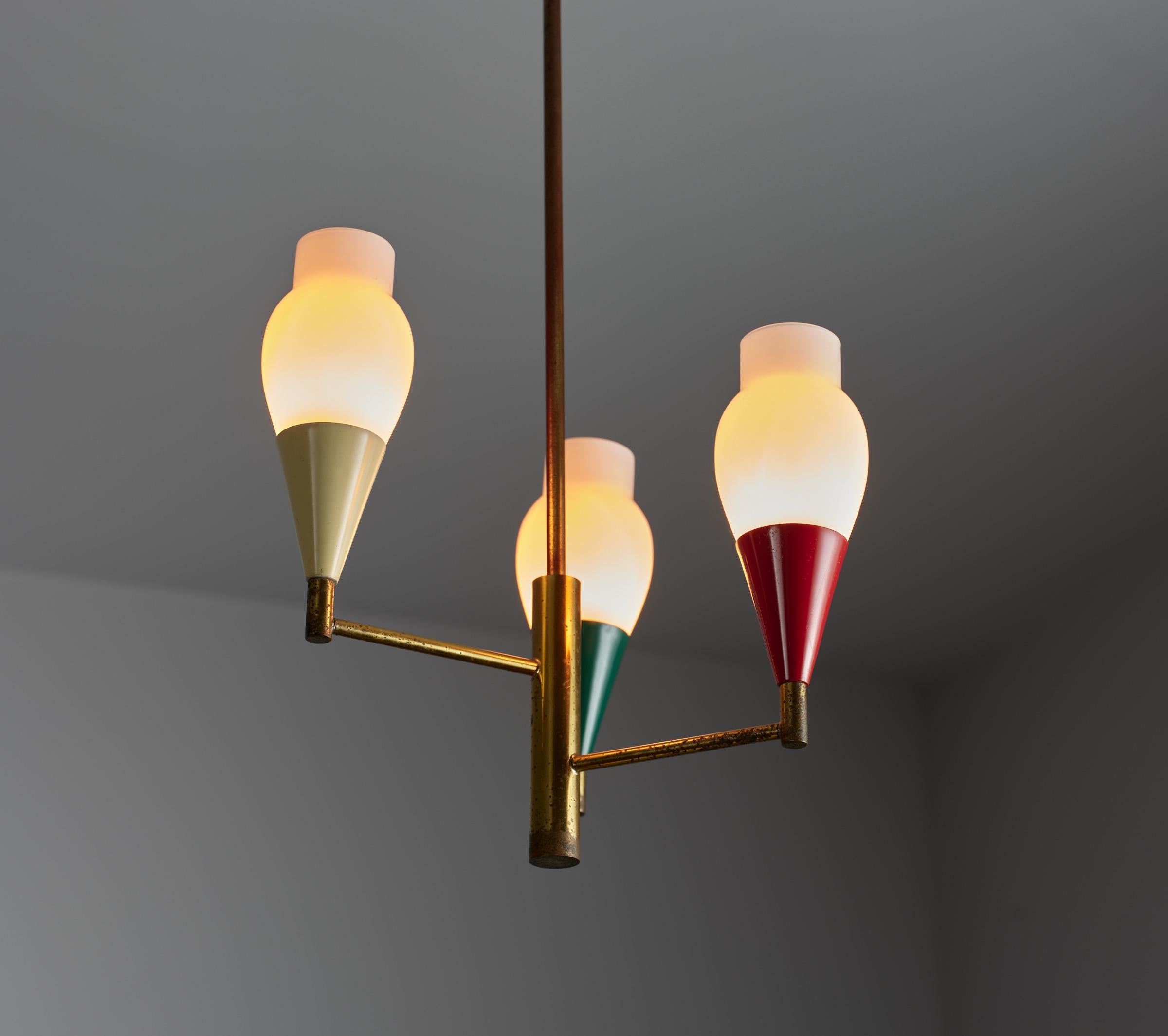 This elegant vintage Italian chandelier, crafted in the 1950s, boasts a modern design with a touch of retro charm. Made from brass, it showcases distinctive signs of oxidation that add character to its appearance. The chandelier features three