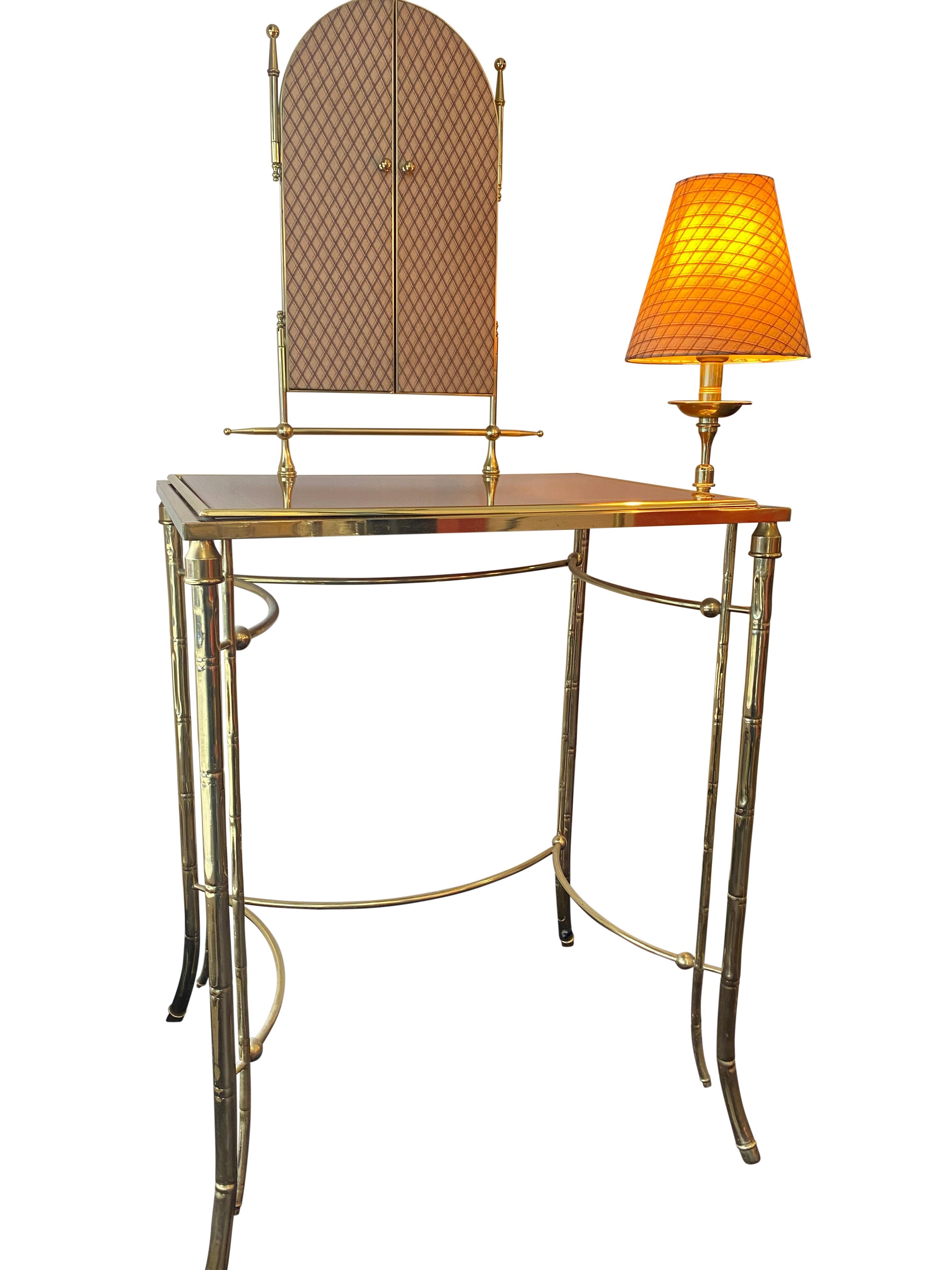 An elegant Italian dressing table in brass faux bamboo with integrated light and triple vanity mirror.



 