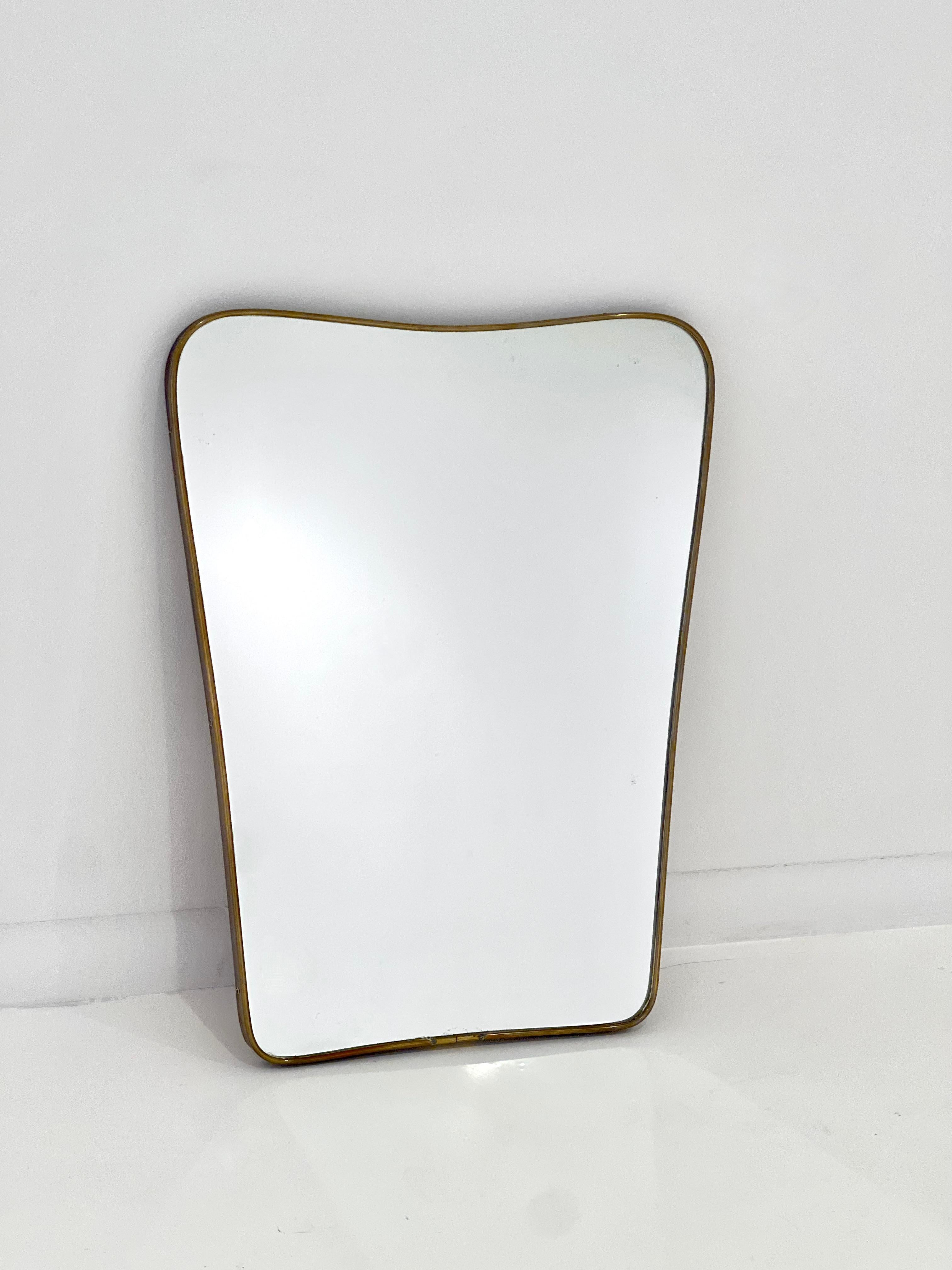 1950s Italian modernist wall mirror with arched shaped patinated brass frame, in the iconic design style of Gio Ponti.