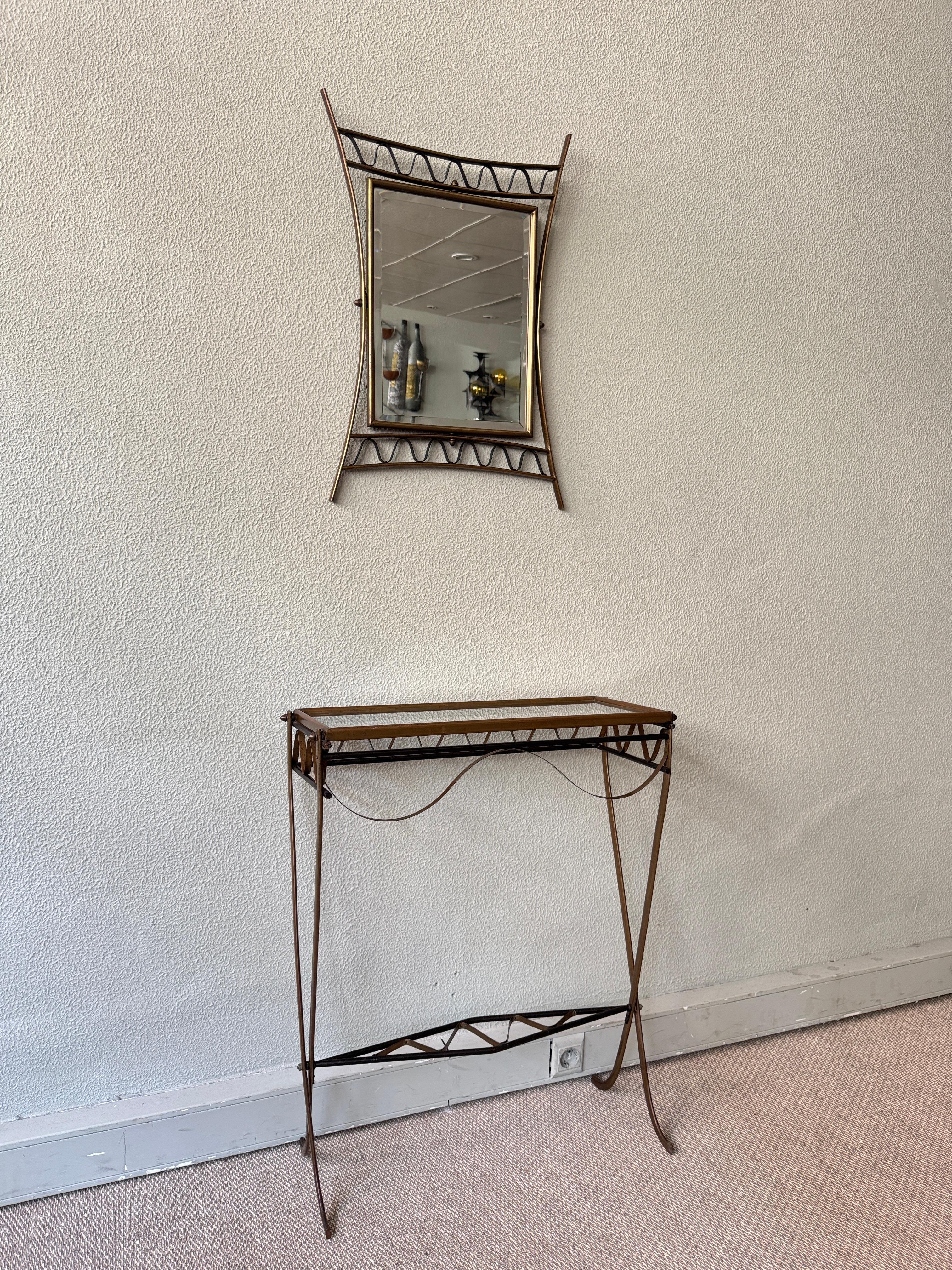 Un sorprendente set di console e specchi della metà del secolo scorso, realizzato in ottone patinato, ferro battuto a mano e vetro. Questo elegante insieme incarna lo spirito romantico del design italiano del dopoguerra con le sue linee scultoree,