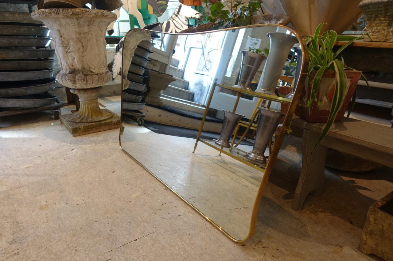 Stunning vintage Italian brass framed mirror from the 1950s. Original glass and gorgeous curvaceous profile. Can be attributed style wise to the designer Giò Ponti. Wall hanging attachments on the back.