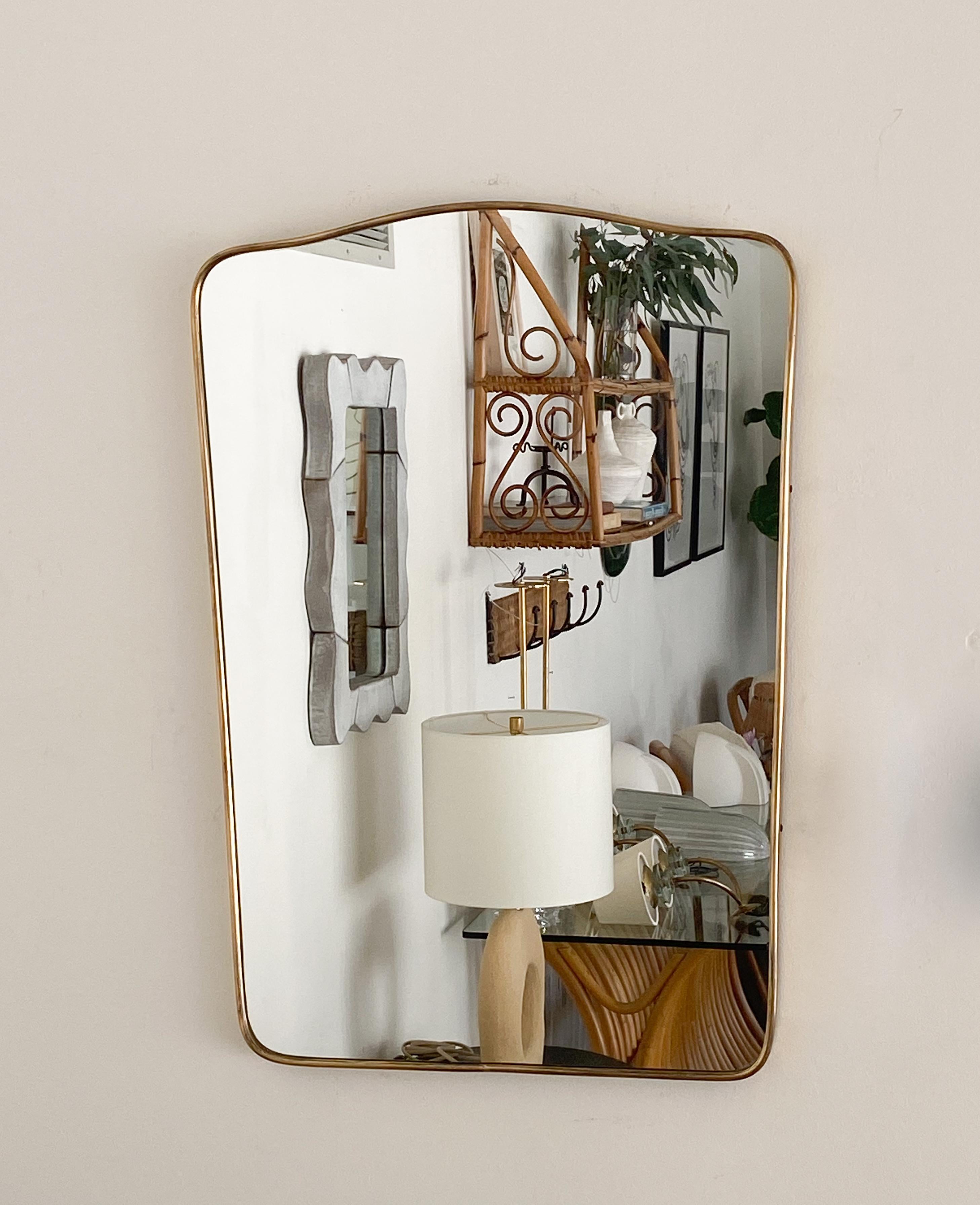 Vintage Italian mirror with brass frame in shield shape. Original brass finish with nice age and patina.