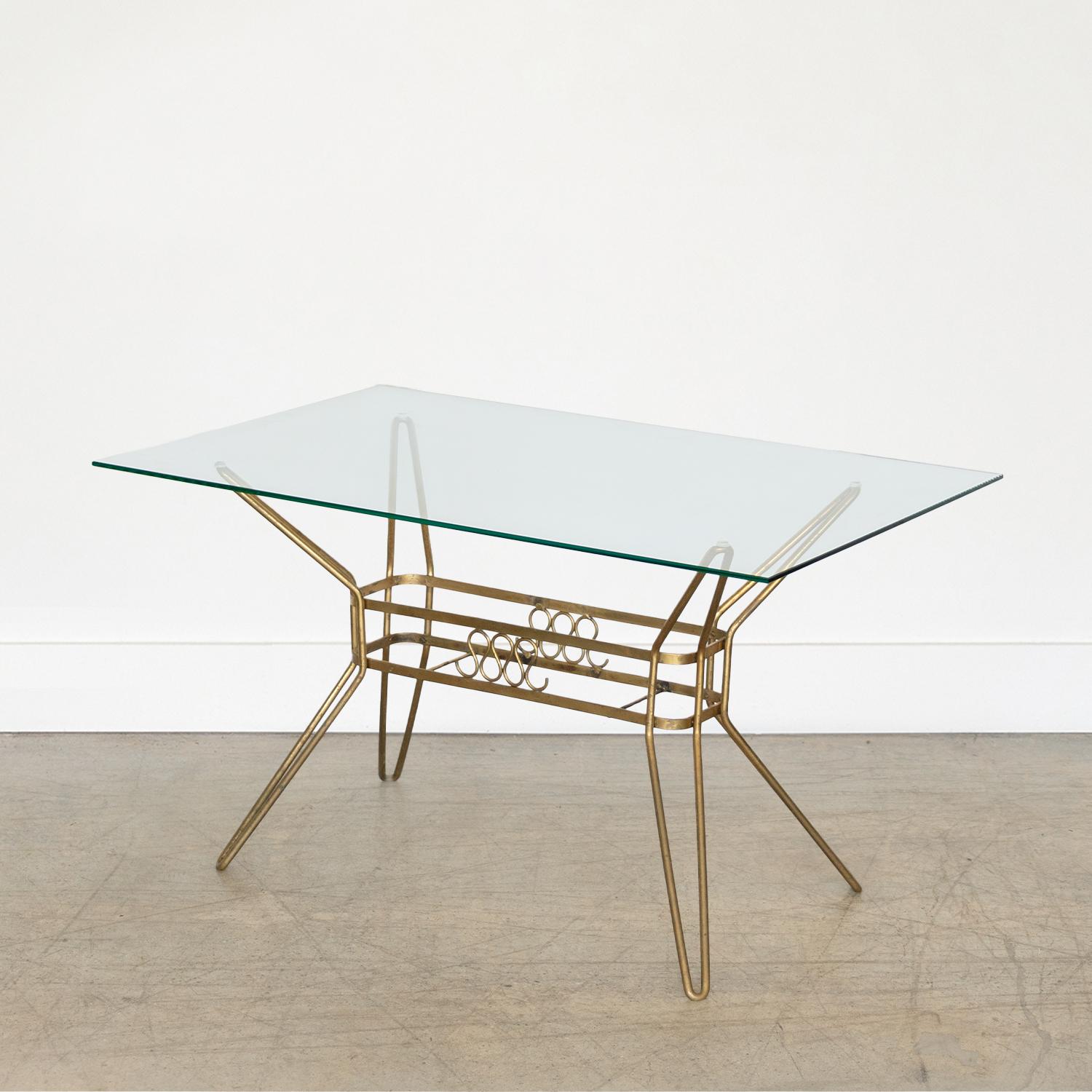 Stunning Italian brass rectangular table with glass top from the 1950s. Original brass base with four angled hairpin legs and beautiful loop detailing at center. Newly made glass top. Perfect for a side or small coffee table. Original finish shows