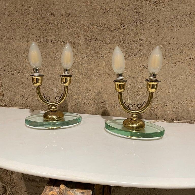 Pair of Italian Brass Candelabra Table Lamps 
Floating oval glass base.
Lamps are unmarked.
6.5 W x 3.5 D x 6.5 H (base of the socket)
Each table lamp requires 2 E-14 bulbs-not included.
No shades.
Very pretty sculptural body with original patina.