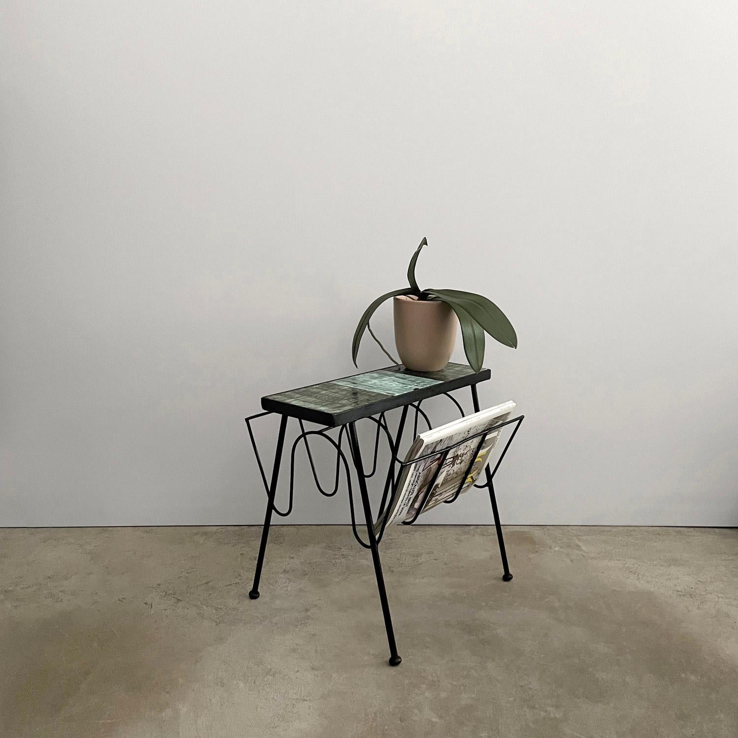 Italian ceramic iron magazine table
Italy, circa 1950s
Sleek, slender and multi-functional 
This little table packs a punch 
Upper portion has organic ceramic tiles which create the perfect side table surface 
Sculpted iron base has two angled