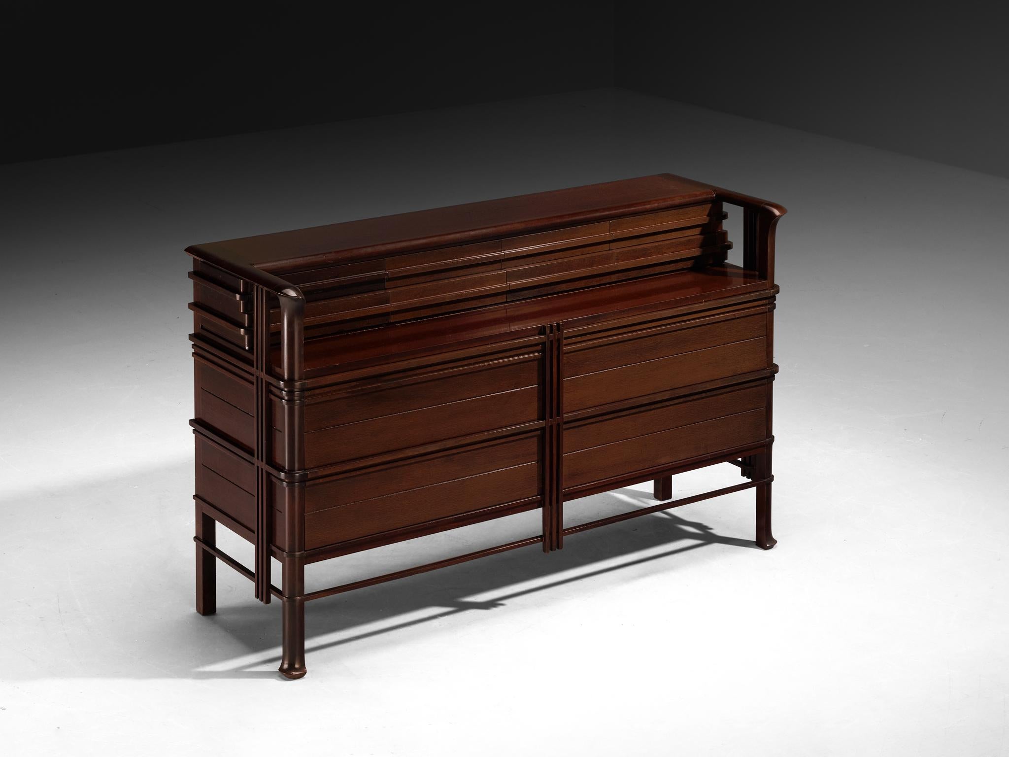 Chest of drawers, red stained wood, Italy, 1950s

This Italian cabinet from the 1950s presents an unusually architectural interpretation of domestic storage furniture. Its form is defined less by ornament than by structure, yet is it is far from