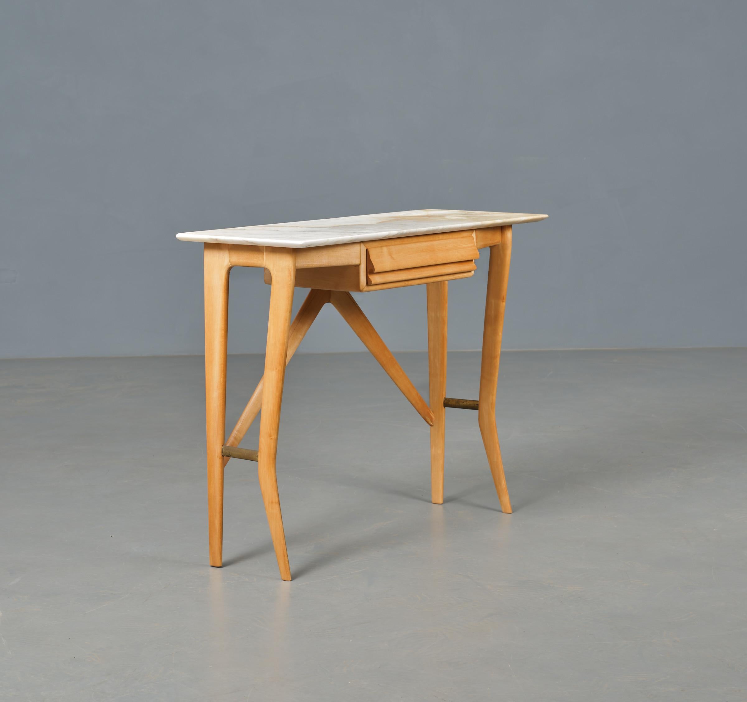 Presenting an exquisite Italian-designed console table from the 1950s. Crafted with a sculptural form and refined elegance, it features a stunning marble top paired with an ash wood frame accented with brass details. Equipped with a spacious drawer