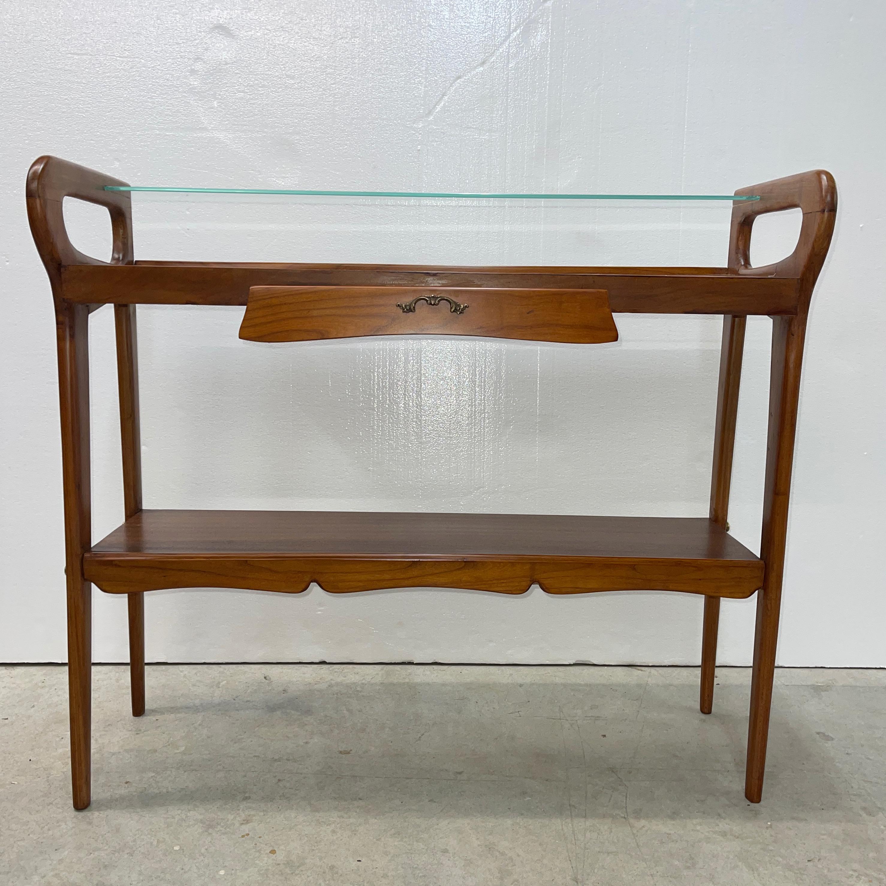 1950's Italian console table in the manner of Ico & Luisa Parisi for Angelo De Baggis, Cantu. A glass insert shelf over two fruitwood shelves with a single drawer, all joined by the shaped open sides, characteristic of the period. 