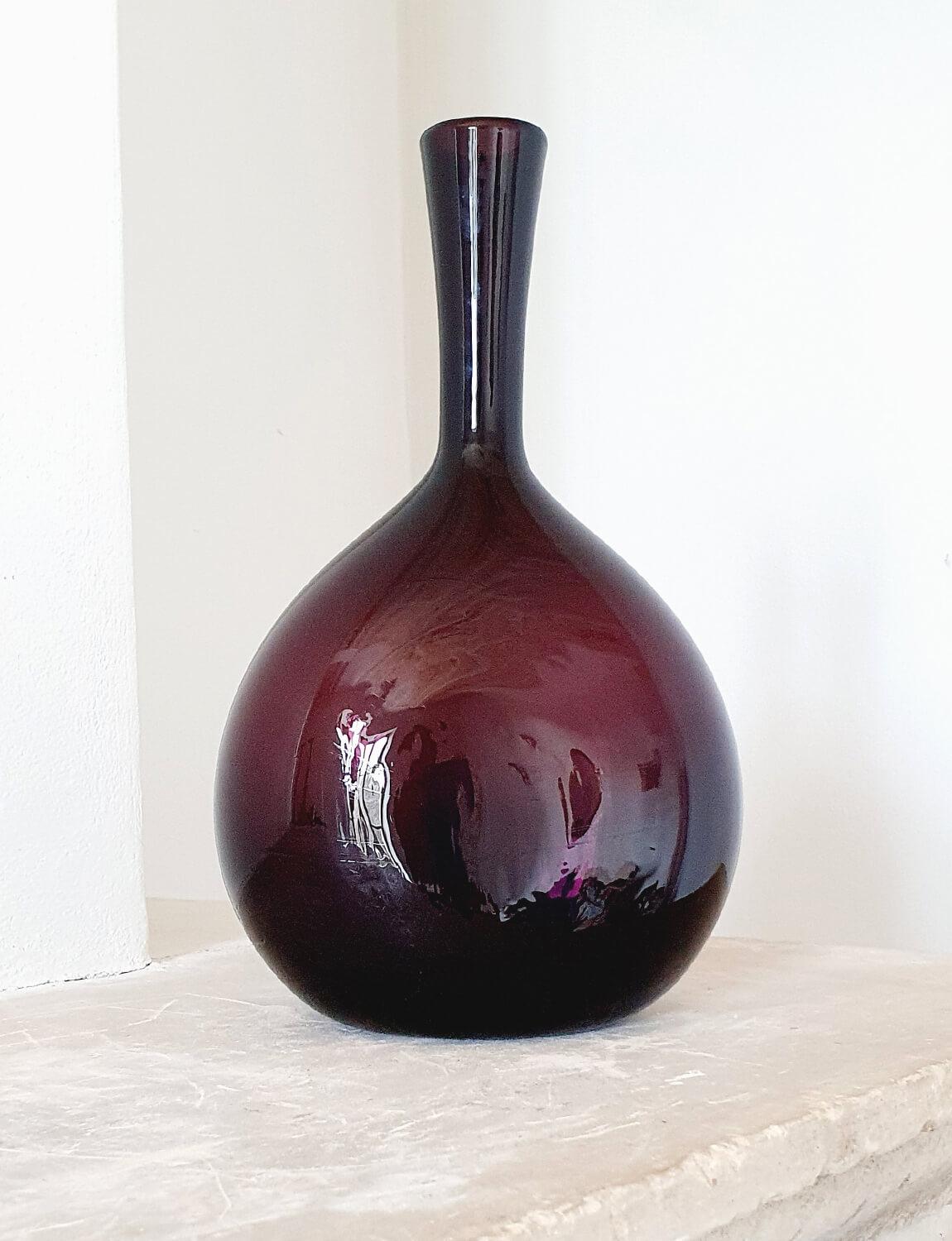 An Italian hand-blown Empoli Glass wine bottle made in a cranberry coloured (dark purple) glass. This exceptional bottle was hand-blown in Empoli in the 1950s. In the last century Empoli in Tuscany was one of the most famous glass-blowing regions of