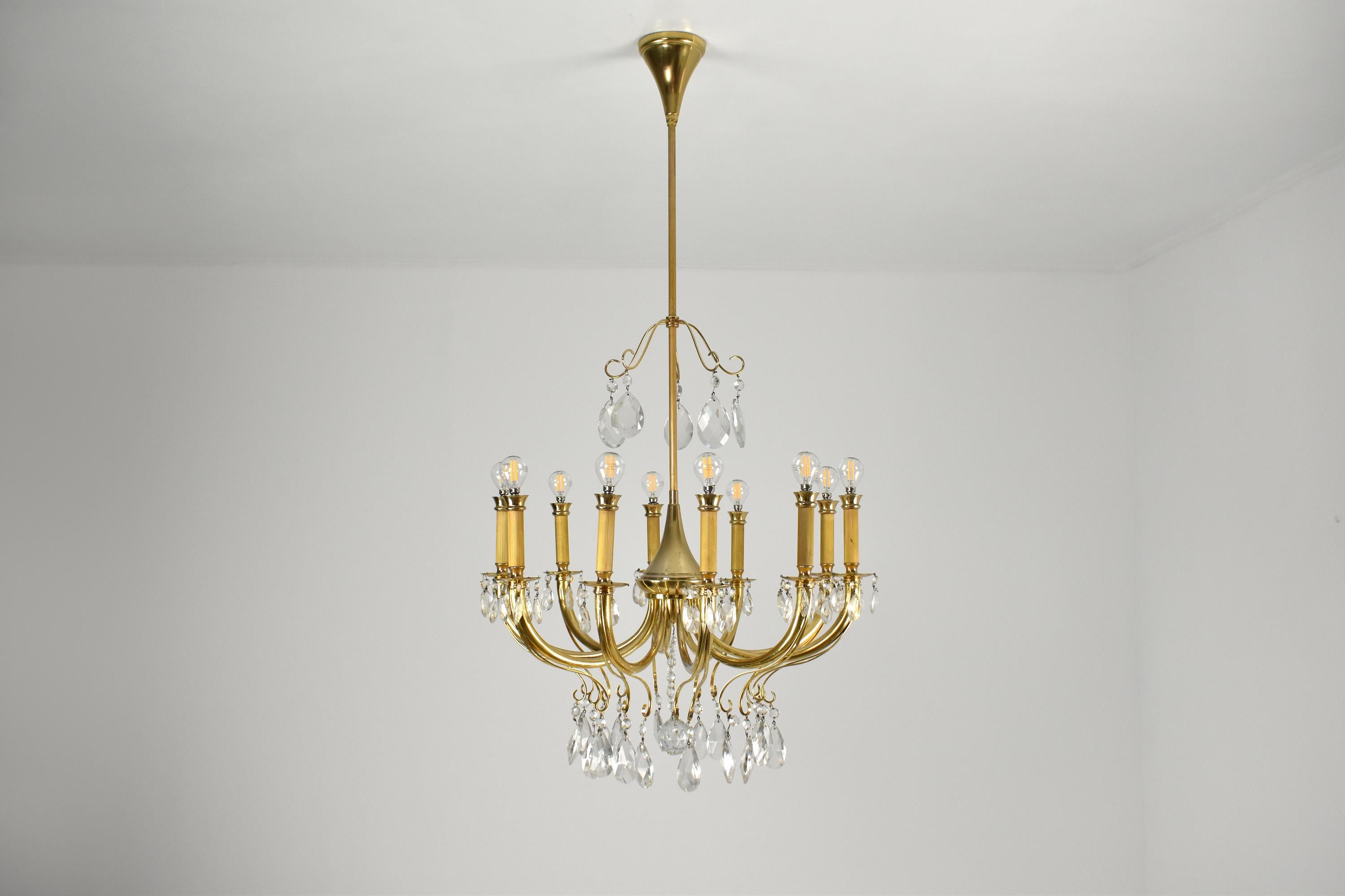 A fantastic 20th-century Italian vintage 10-light chandelier from the 1950's hanging via a slender solid brass structure. 
Beautiful gold brass candelabra style light. 
Professionally restored. 
Original label. 

-------
We are an exhibition