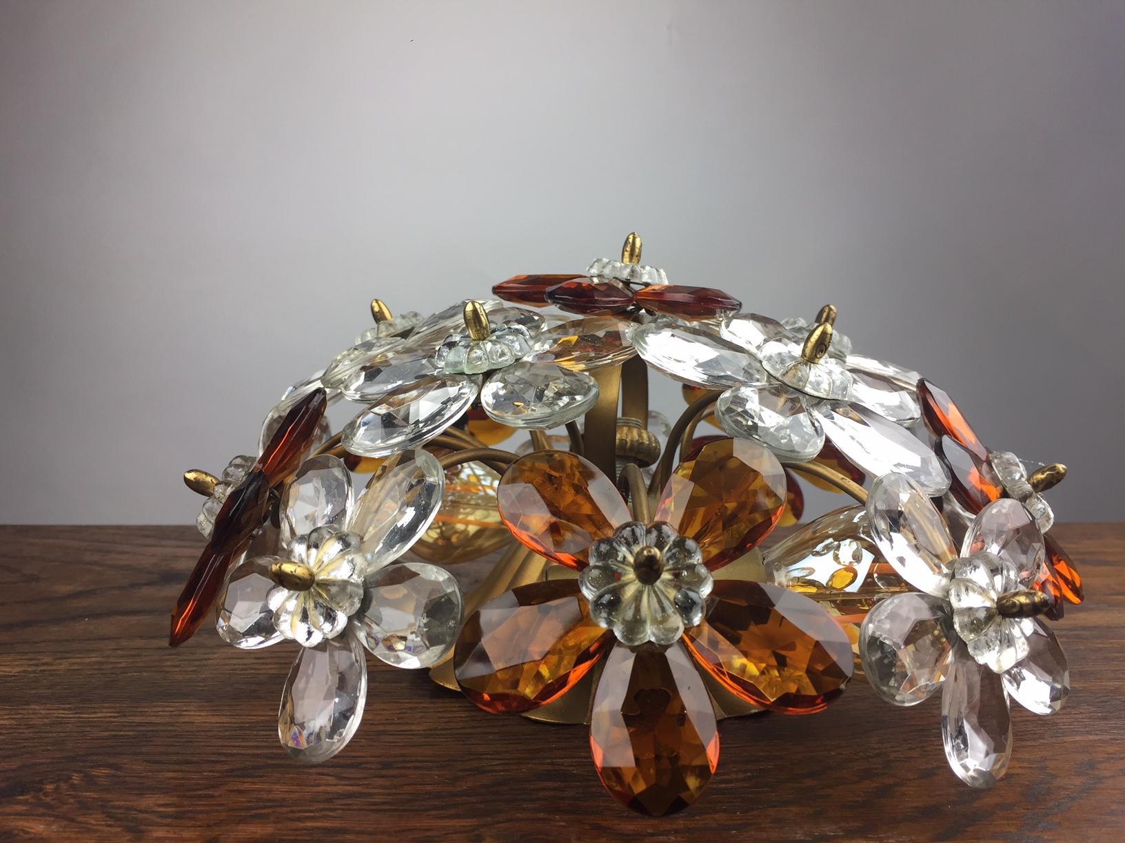 Stylish Italian Gilt Metal Ceiling Lamp decorated with Crystal Glass Flowers.
Flush Mount with Clear and Amber-Colored Cut Crystal Glass Flowers.
Vintage Flowered flush mount, Flower light from the 1950s.
Two bulbs, E14 fitting
 