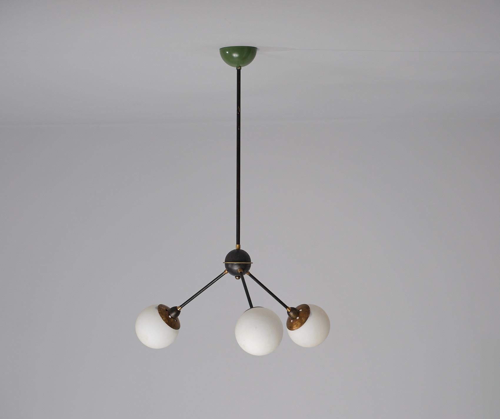 In offerta c'è un accattivante lampadario degli anni Cinquanta, che mostra un distinto design italiano attribuito a Stilnovo. Comprende un tubo centrale discendente che si dirama graziosamente in tre bracci, ognuno dei quali è ornato da diffusori a