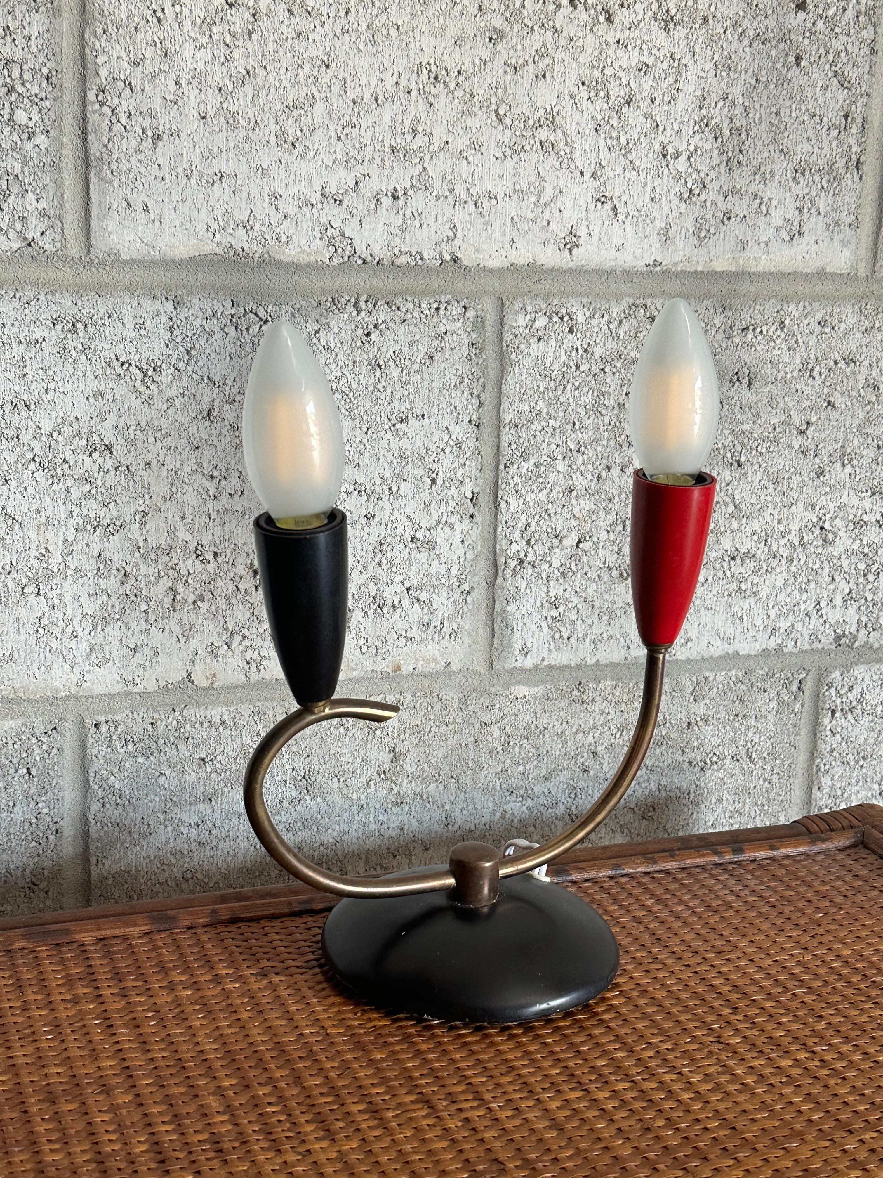 Une charmante lampe de table probablement produite en Italie vers les années 1950. Comprend deux feux - l'un avec un boîtier noir et l'autre avec un boîtier rouge. Un léger piqué crée un merveilleux mouvement organique. Marqué sur le fond 