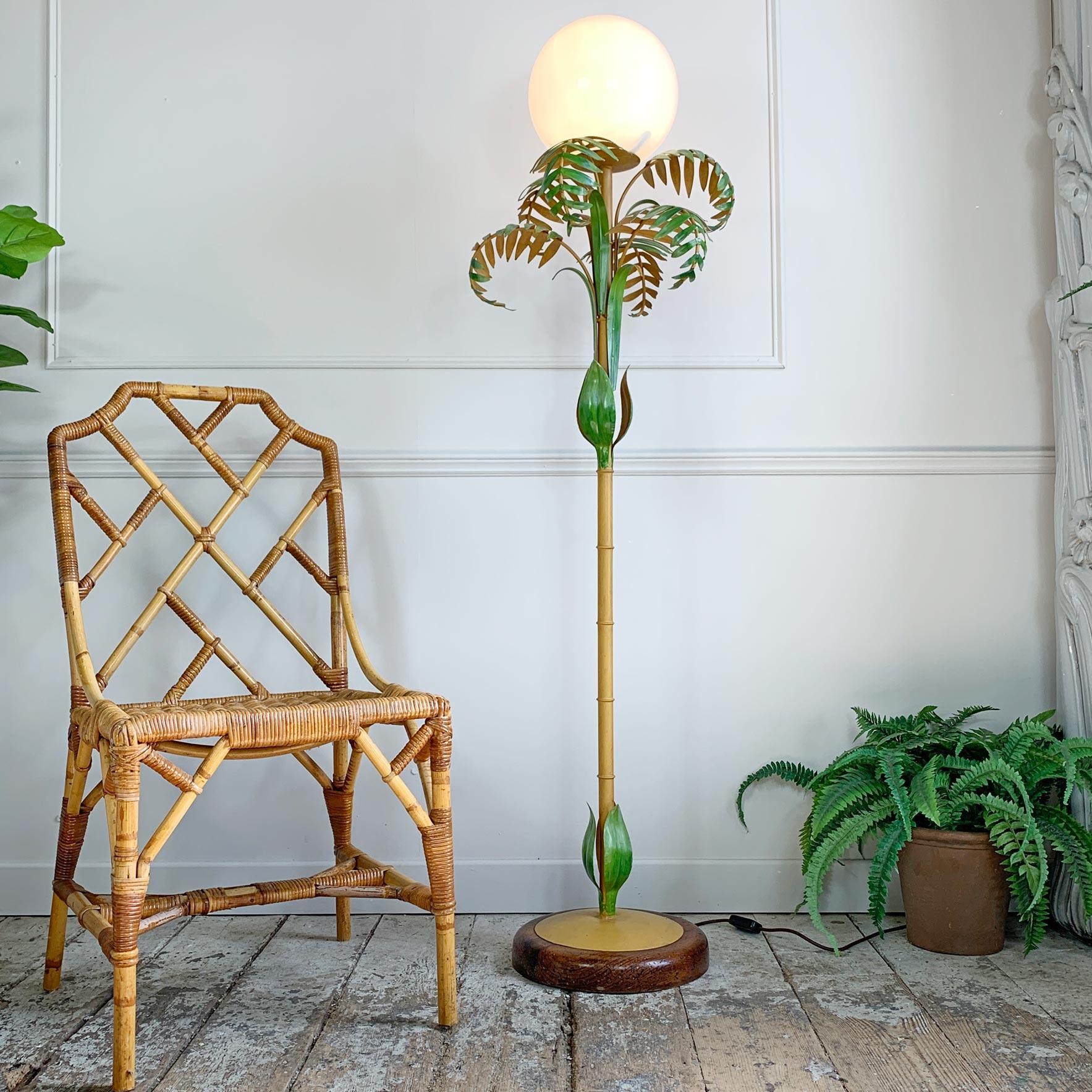 An Italian hand painted faux bamboo floor lamp, dating to the 1950’s. The central bamboo stem resplendent in faux bamboo leaves and foliage, with a single lamp holder that sits below a huge hand blown opaque glass globe.

The turned wooden base