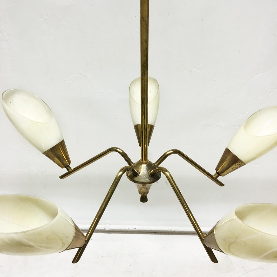 Elegant midcentury 1950s Italian five branch brass and glass ceiling light, chandelier, pendant. It has a solid brass frame supporting five pastel yellow shades, which have fine white pinstripes. When the five E14 bulb holders are lit, the shades
