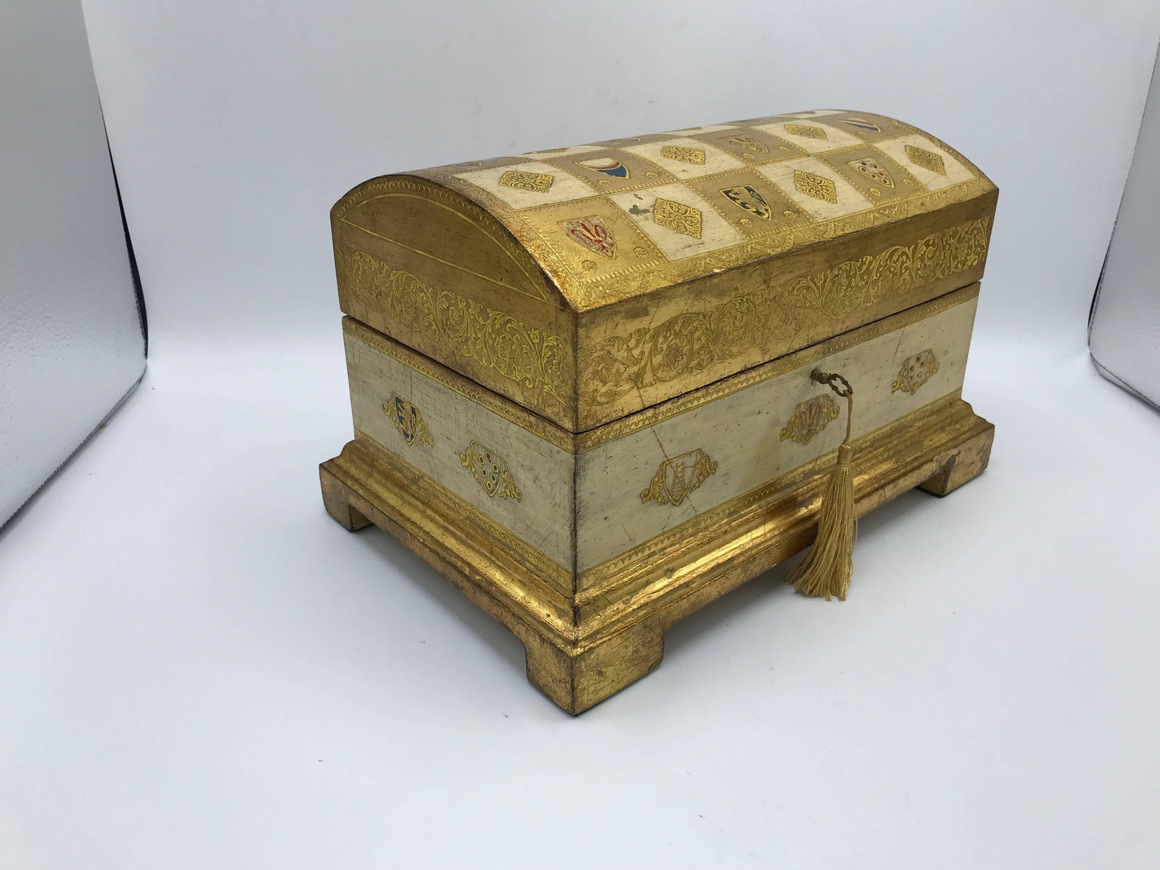 Listed is a gorgeous, 1950s Italian Florentine box/chest with an all-over crest motif. The piece is fully-functional, including its original key.